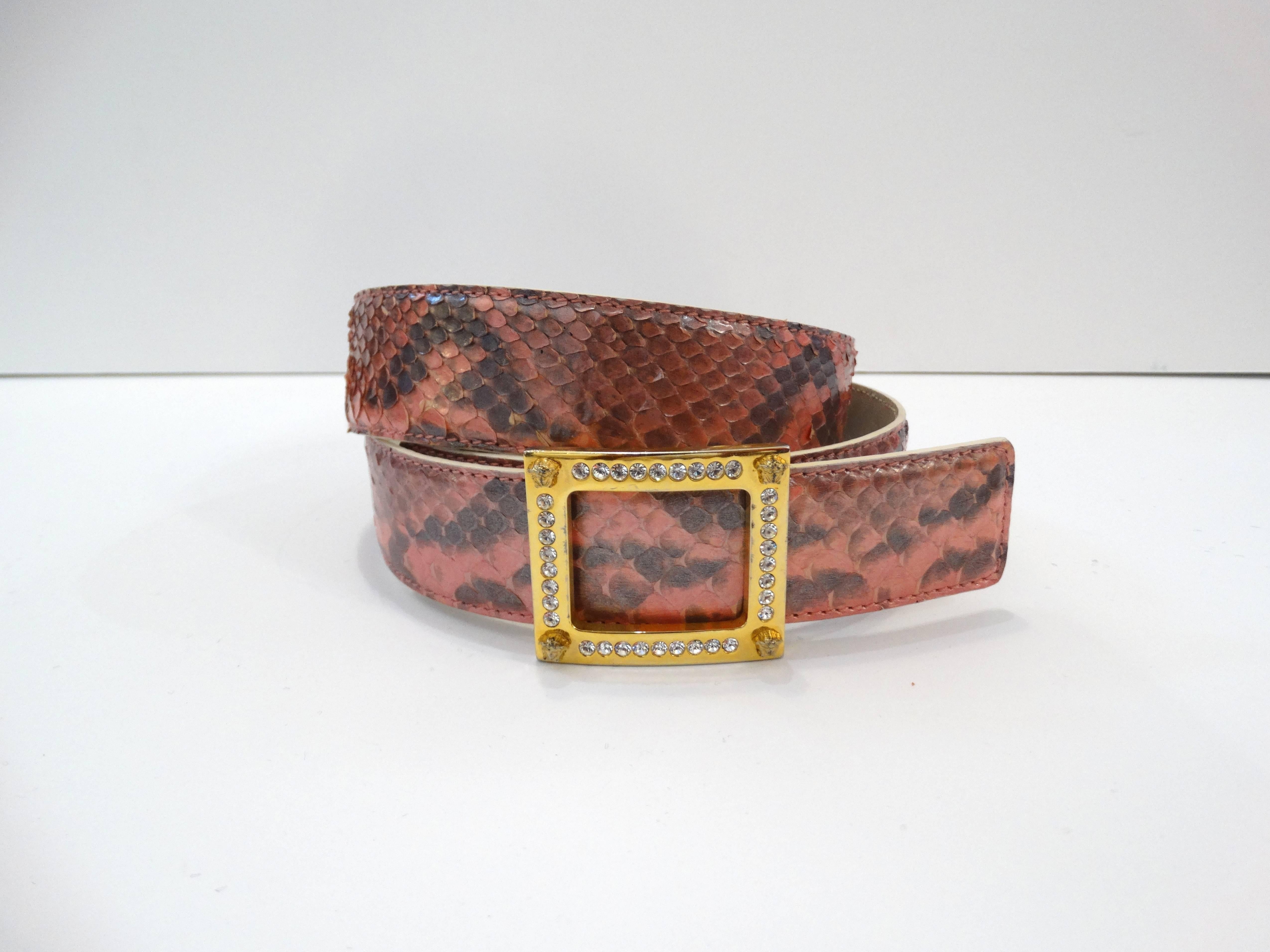 Adorable 1990s Gianni Versace pink snakeskin belt! Gold metal square belt bucket accented with angel heads and crystalline rhinestones. Peg closure. Pink and black snakeskin material backed by creamy white leather. Some marks on the interior of the