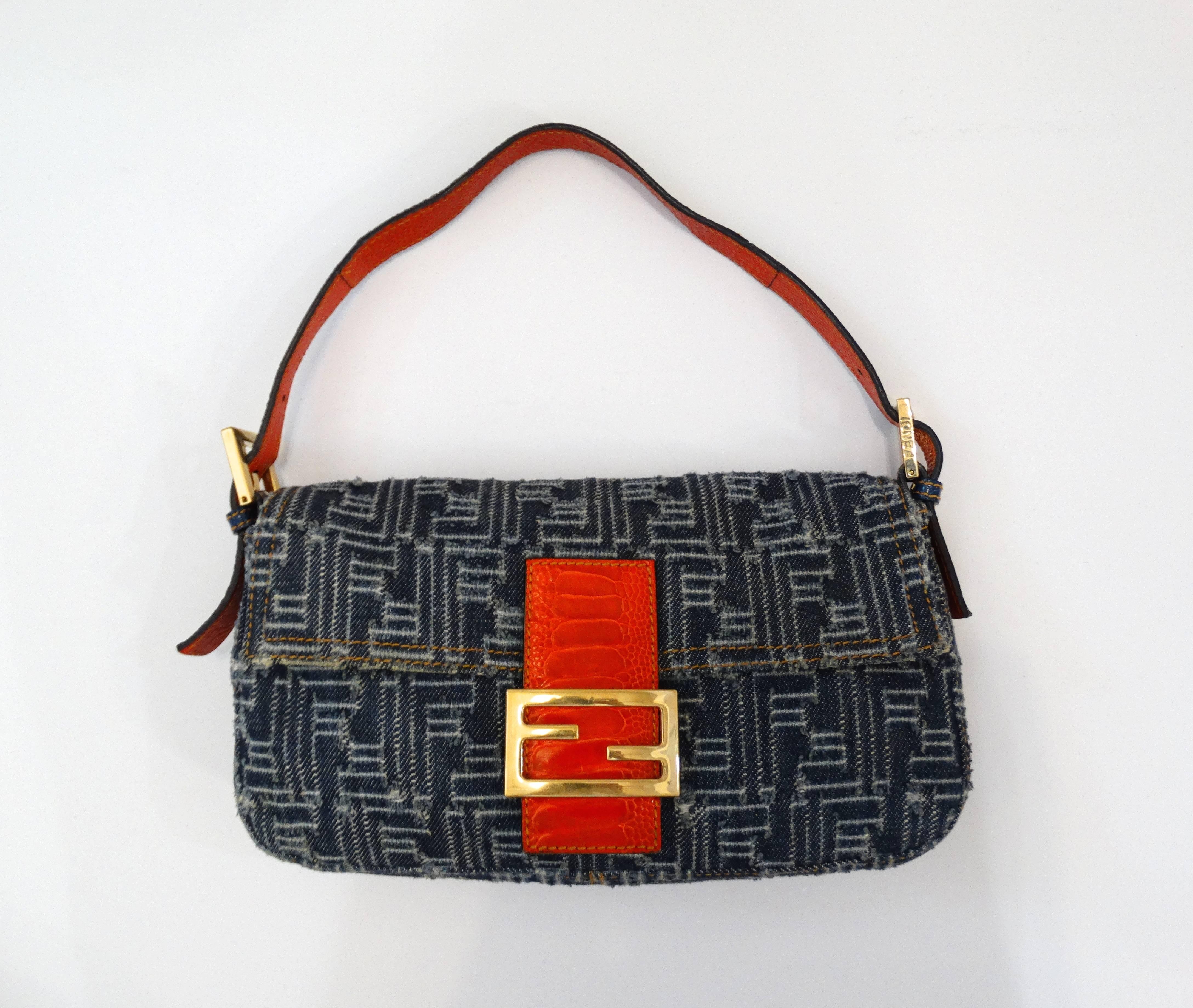 Channel the spirit of the 2000s with our little Fendi baguette! Denim F monogram pattern with orange snake skin embossed leather accents. Gold monogram hardware and buckles on the sides. Fully lined cloth interior with zipper pocket. Snap closure