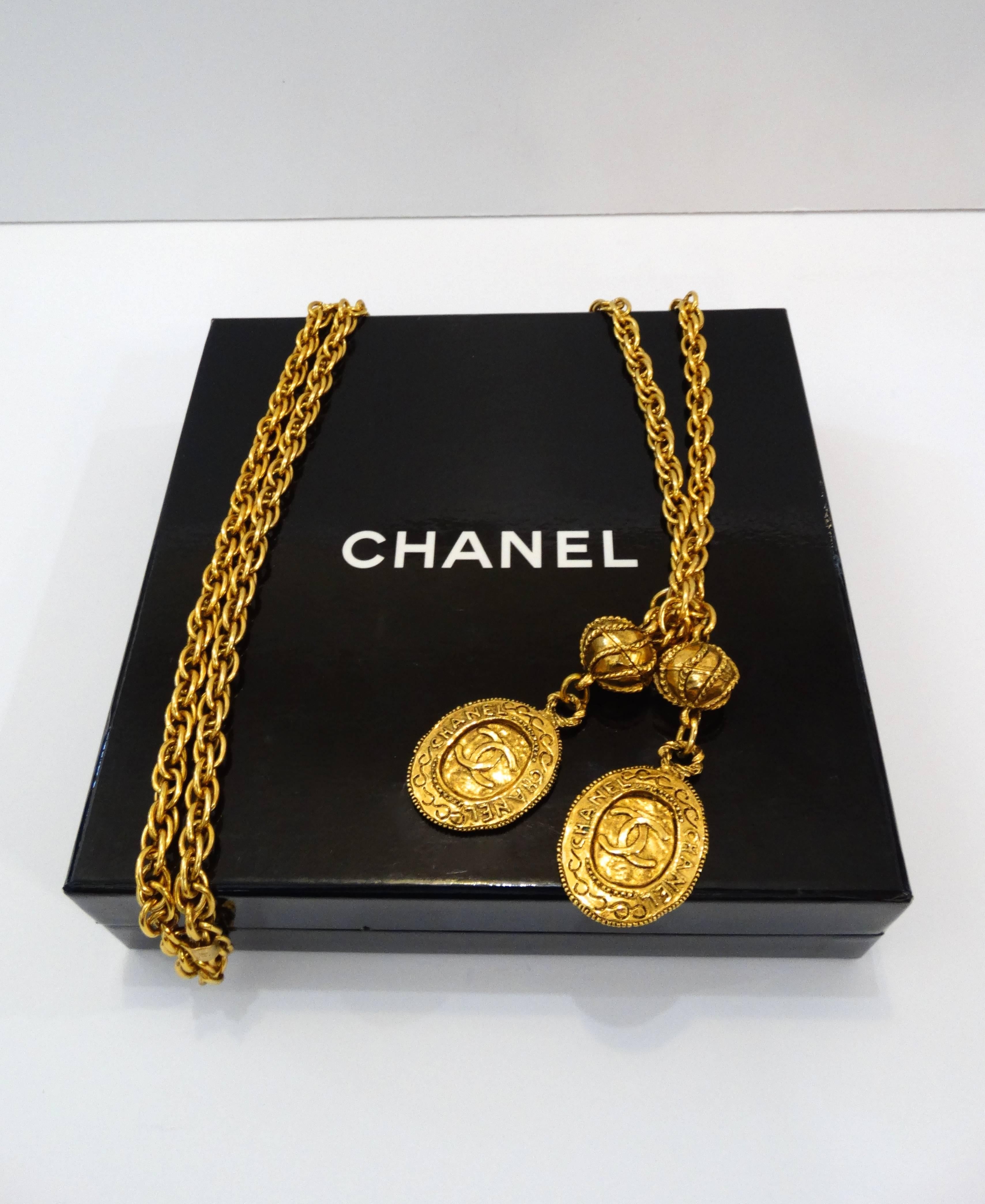 The iconic 1980s Chanel Lariat necklace, is iconic! Bright gold metal chain that knots with two double CC monogram drop charms. Length is customizable- looks amazing layered and doubled up. Chanel signature on little plaque at the back of the neck.