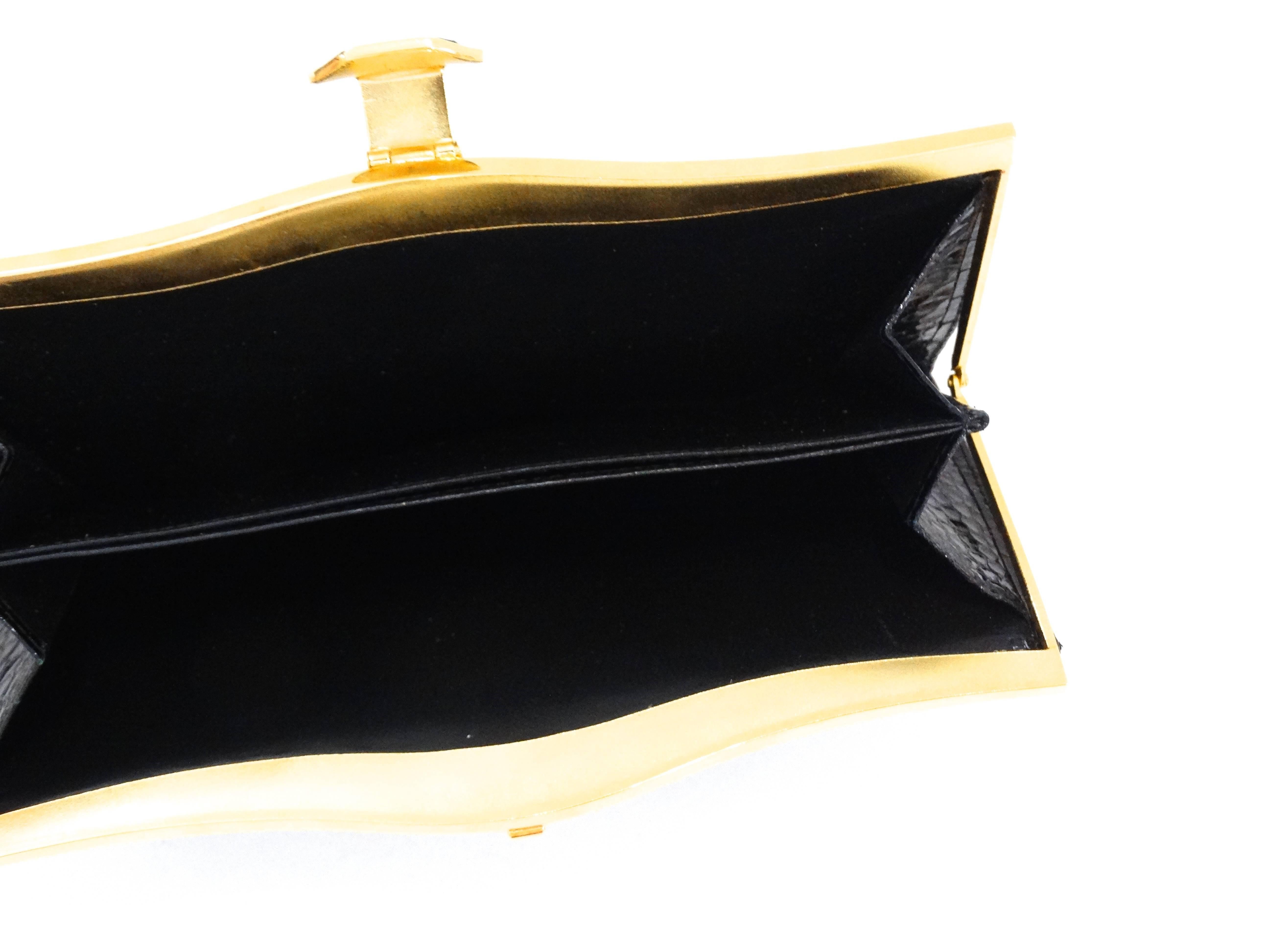 Store your cards in style with our Judith Leiber snakeskin wallet! Made of a black, super glossy snakeskin with matching black leather interior. Gold metal frame with fold over stone clasp that snaps into place. This baby is in unworn condition,