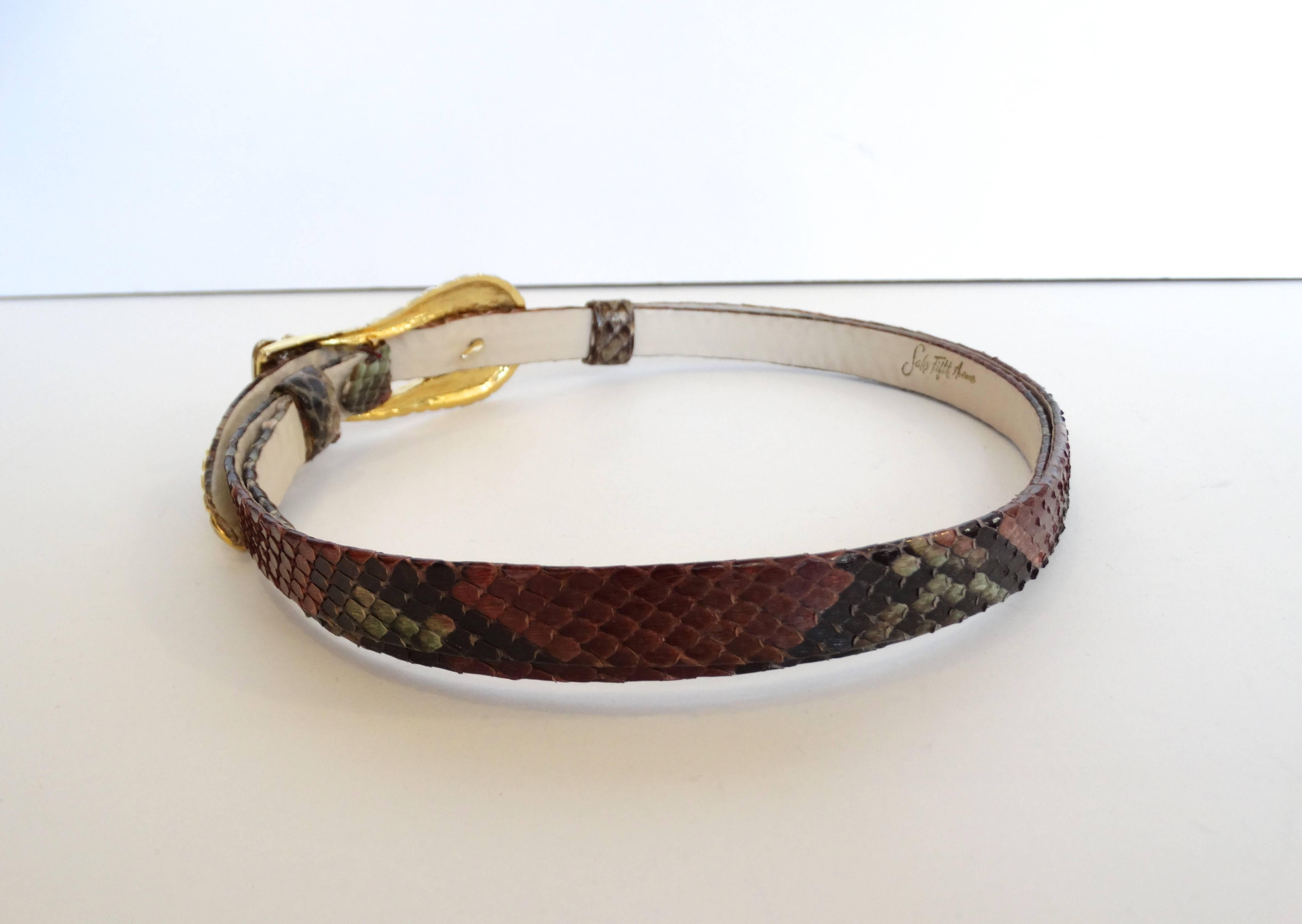Amazing 1980s buckle belt from the iconic designer Judith Leiber for Saks Fifth Avenue! Gold metal belt buckle with silver crown accent. Hooks in the front beneath the buckle. Thin multicolored snakeskin belt adjusts to whatever size you want by