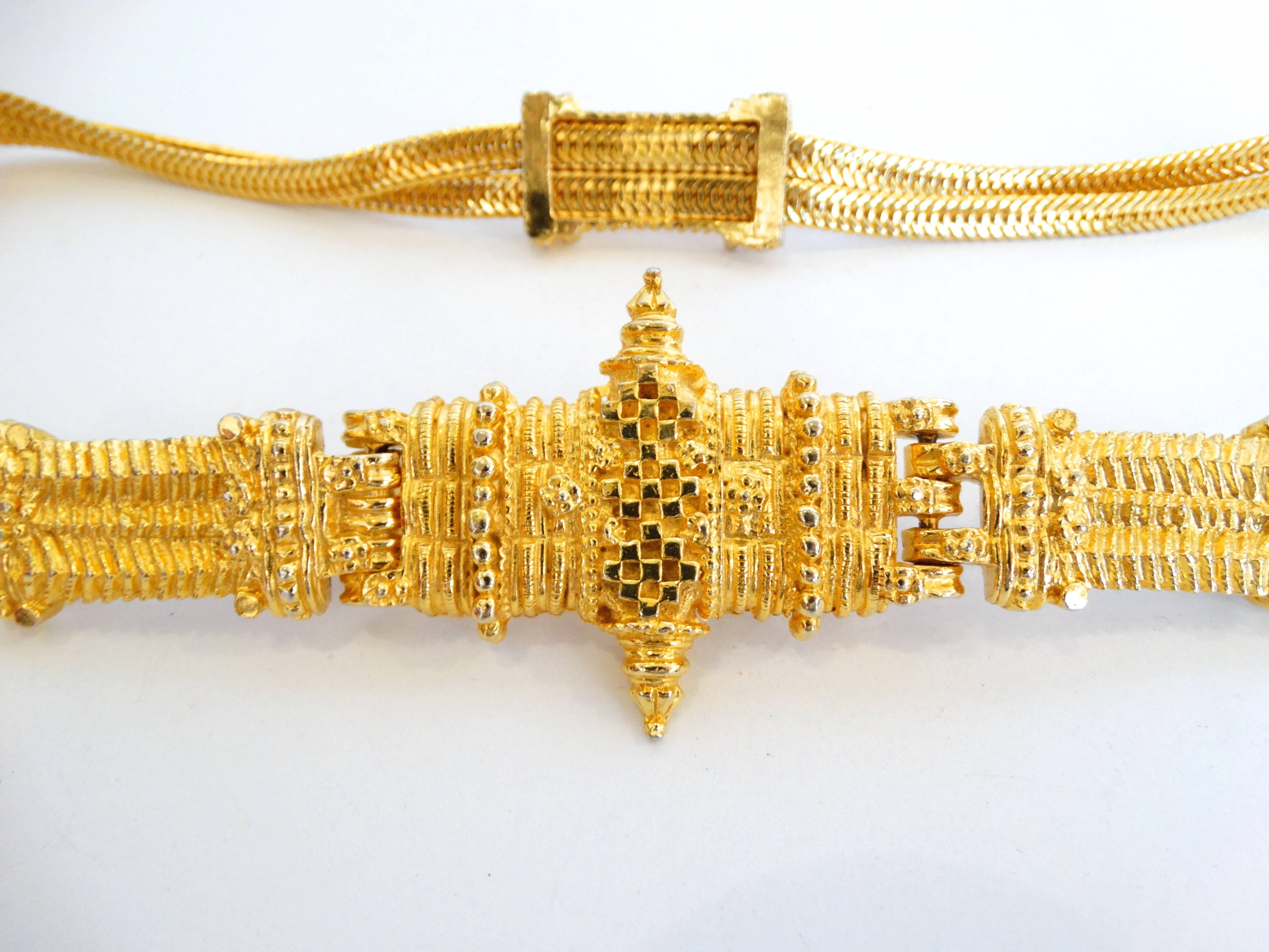 The classiest 1980s gold metallic belt from Judith Leiber! Woven chain construction with buckle tribal accents. Hooks easily in the front. 
Signed at the back of the buckle. Unused

Length: 30”