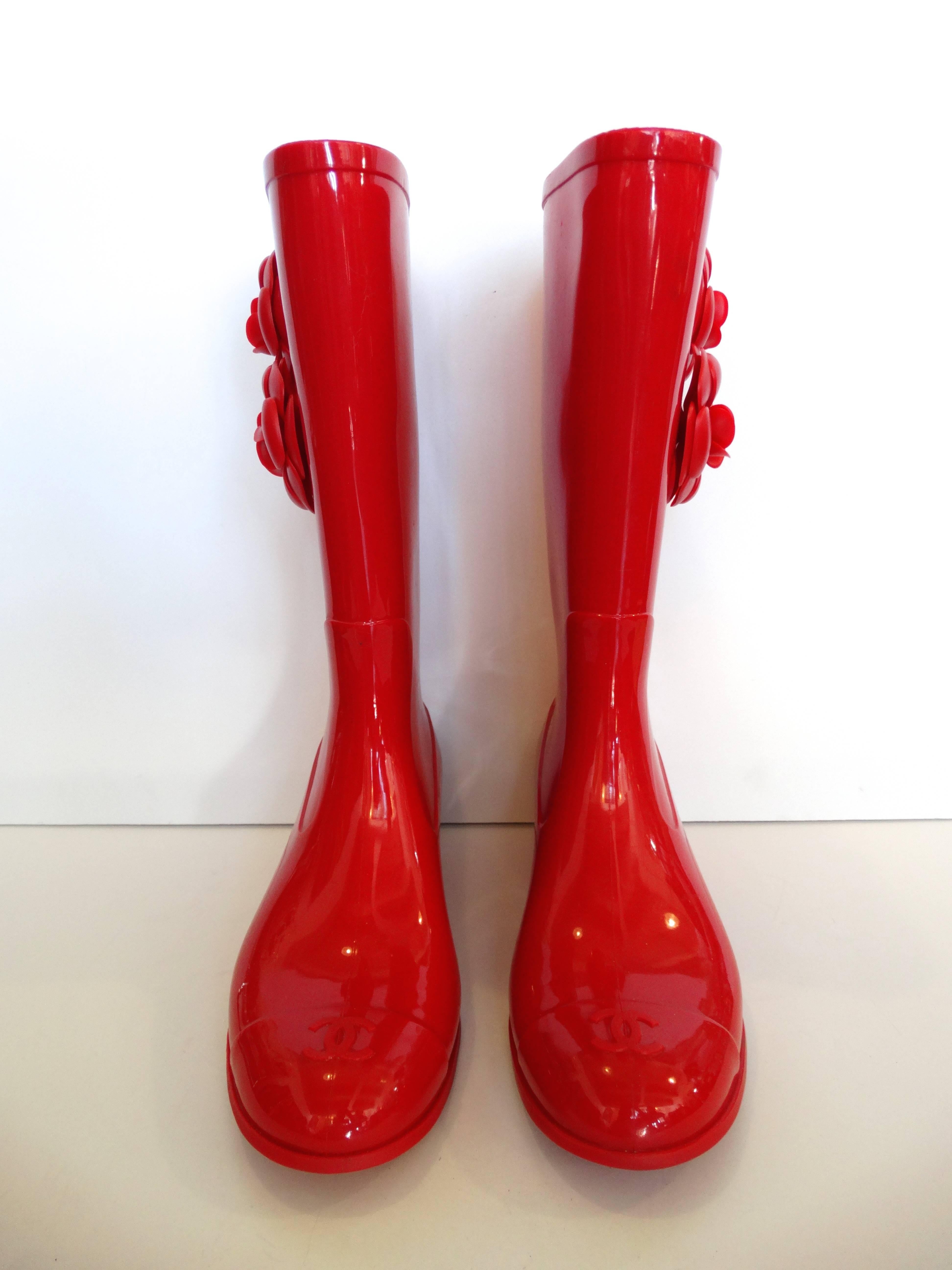 Splash puddles in style in our Chanel Camellia wellies! Made of a glossy red rubber with matching red Camellia flowers on the sides. Small “CC” gold charms on the flowers. “CC” monogram toe caps. In fabulous condition, only a little wear on the