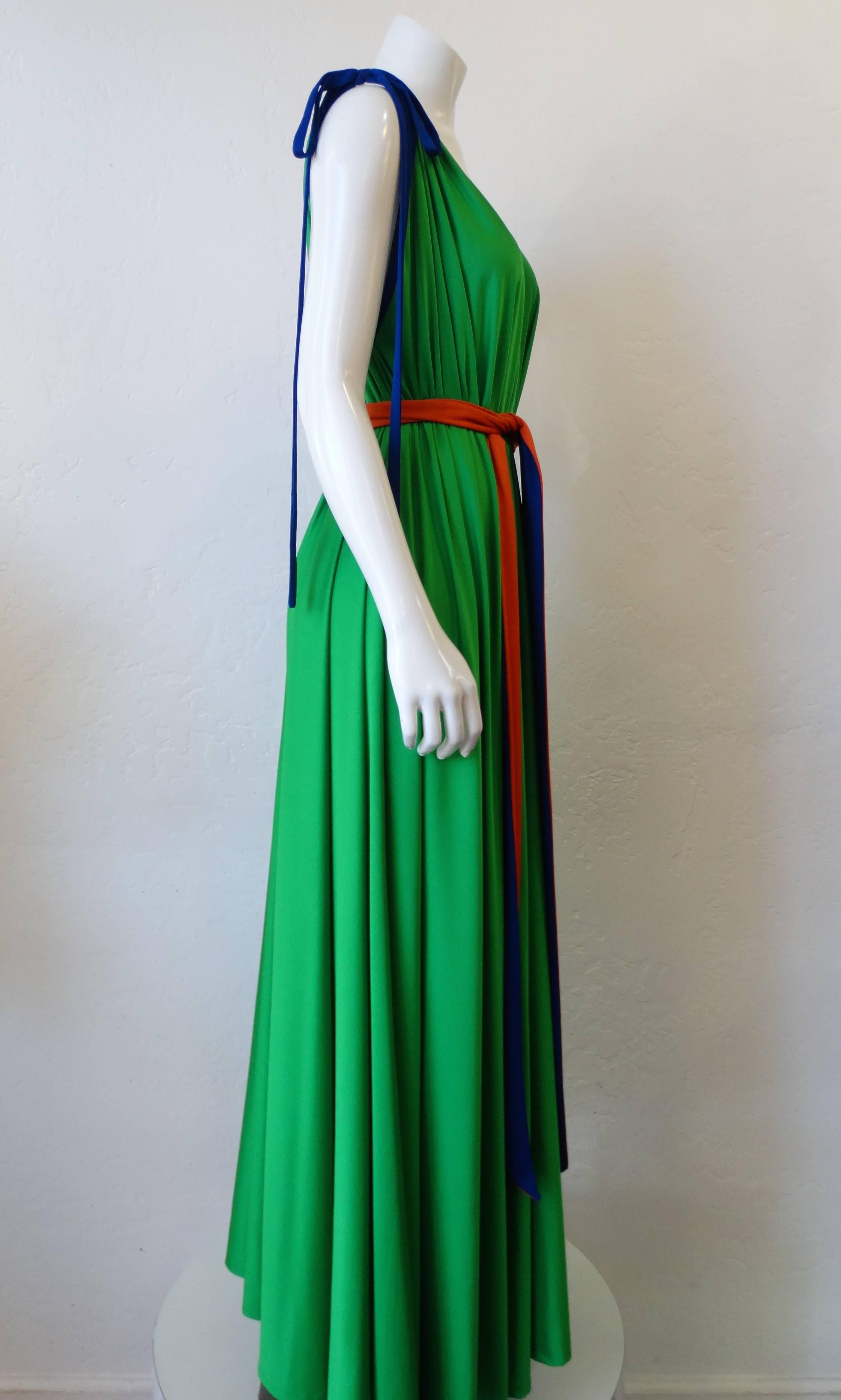 We are obsessing over this Tori Richard Honolulu dress from the 1970s! Beautiful kelly green color accented with complementary blue and orange. Trapeze fit cinched in with matching tie. Two blue bows on either shoulder for an adjustable fit. This