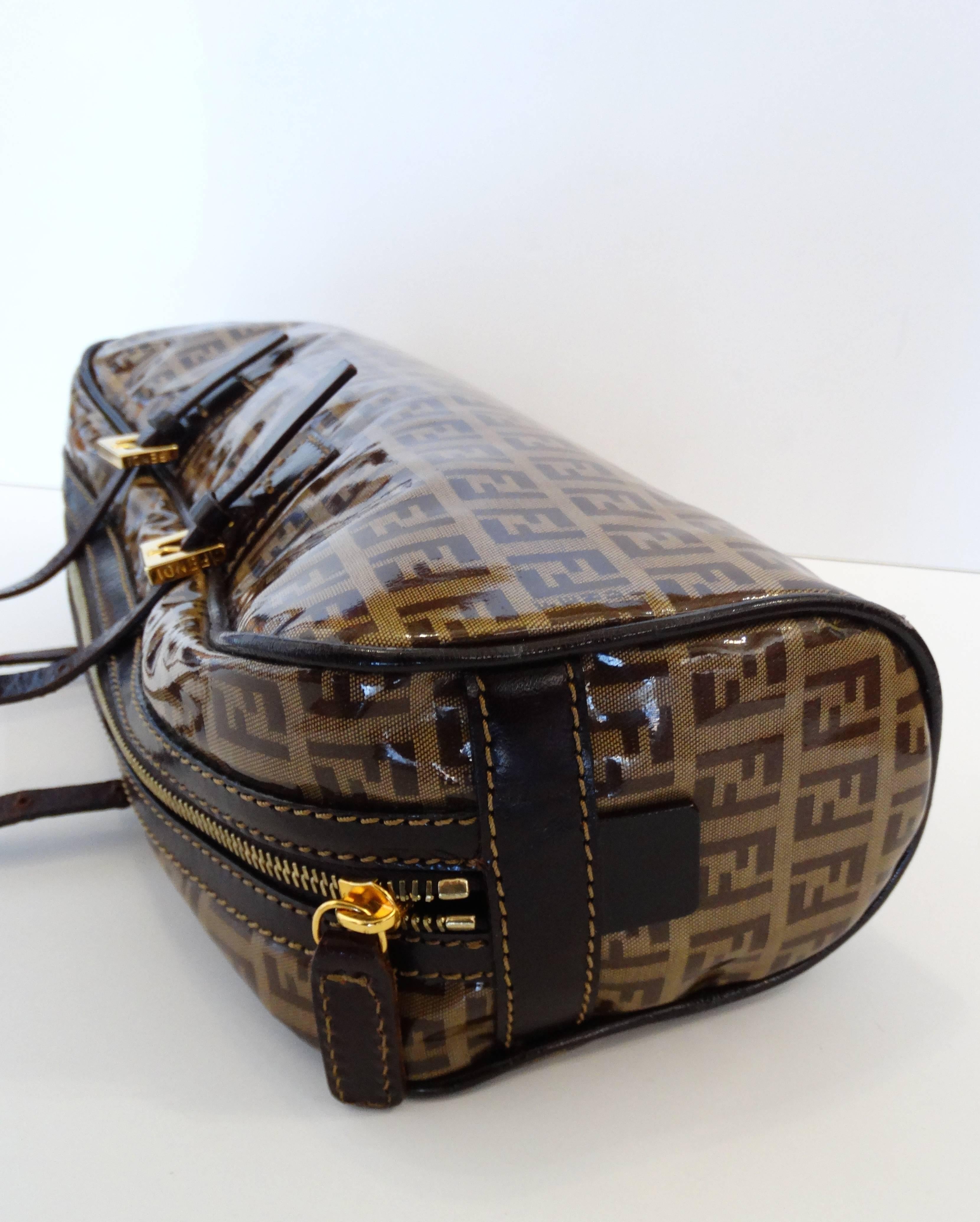 The most adorable little top handle Fendi bag in the brown Zucchino print! Monogram logo printed jacquard fabric with an overlay of vinyl. Dark brown leather straps with gold metal buckles and zipper. Fully lined fabric interior with zipper pocket.