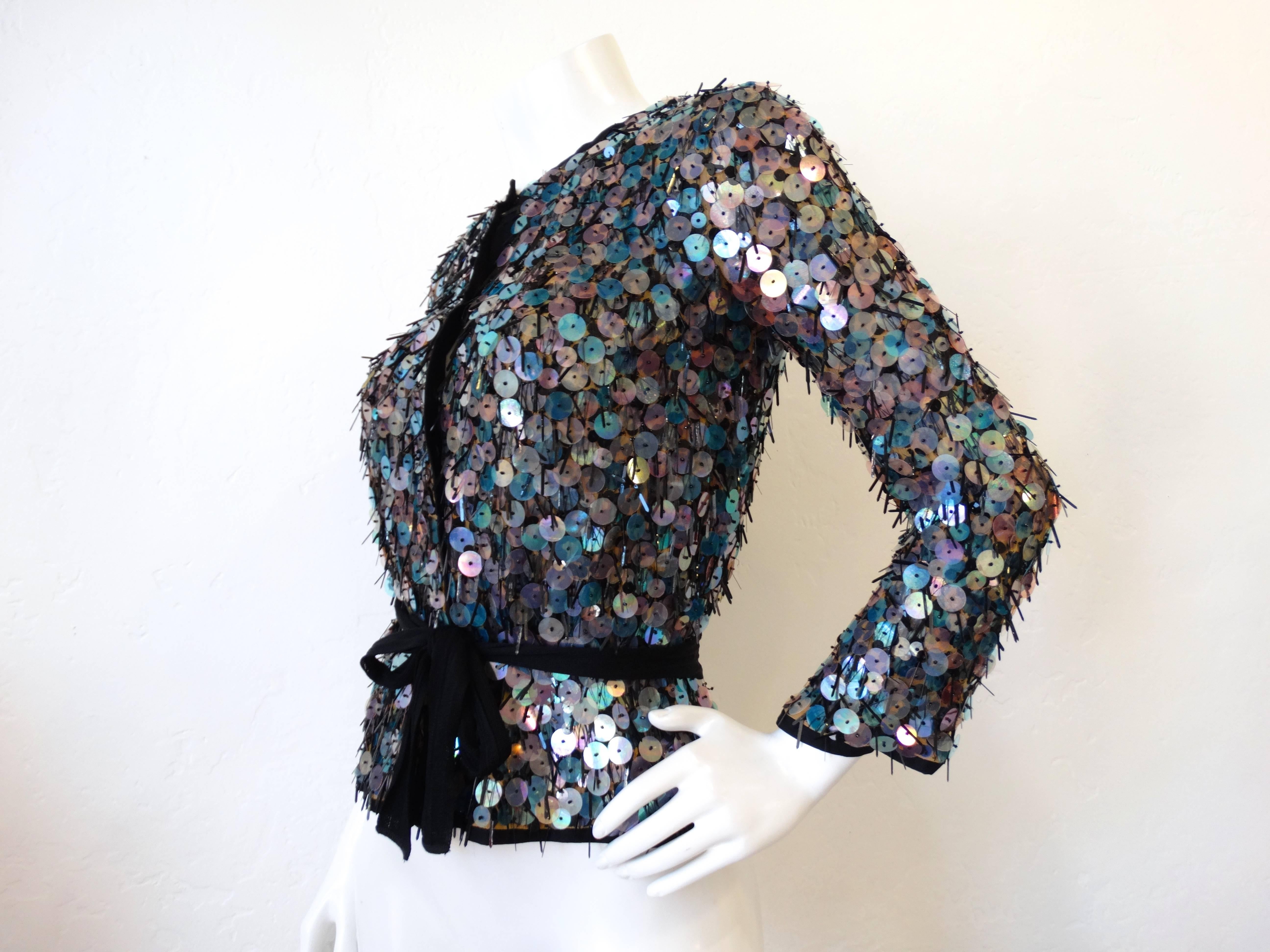 Shimmy and shake in our most fabulous Missoni sequin sweater! This piece is absolutely laden with blue and violet color shifting sequins and beading. Snaps easily up the front. Ties around the waist with a black knit tie. 

Marked a size 42, best