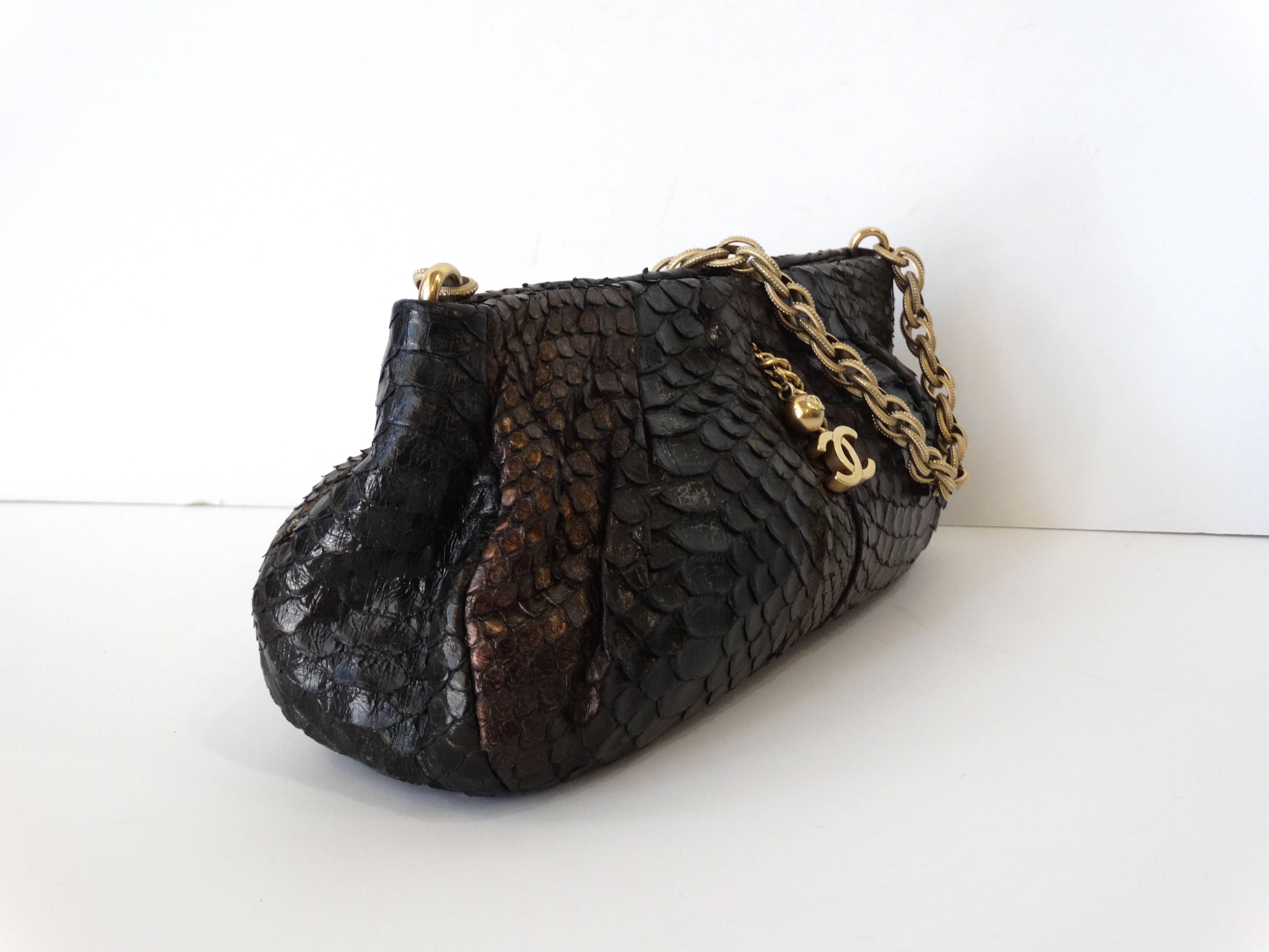 Beautifully constructed in metallic iridescent blend of olive, purple with gray undertones in genuine buttery python skin. This pleated clutch pochette features an aged gold tone bijoux chain strap, front and back CC pearl charms as side bag pulls.