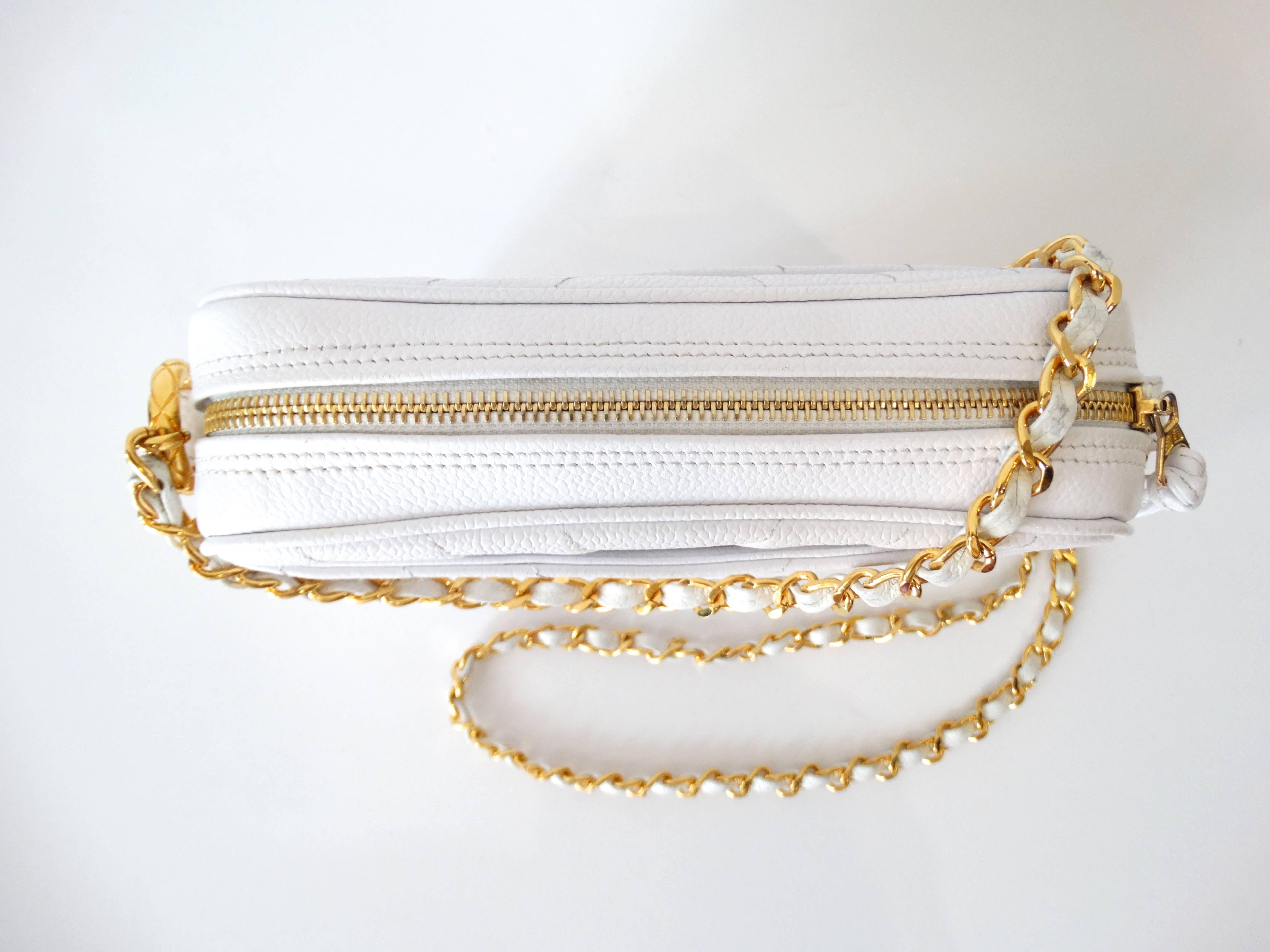 Is there anything more classic than a Chanel bag? Incredible textured caviar leather in an icy white color. Signature Chanel stitching in a unique Chevron pattern. 23” Long cross-body chain in brilliant gold metal with matching white leather. Two