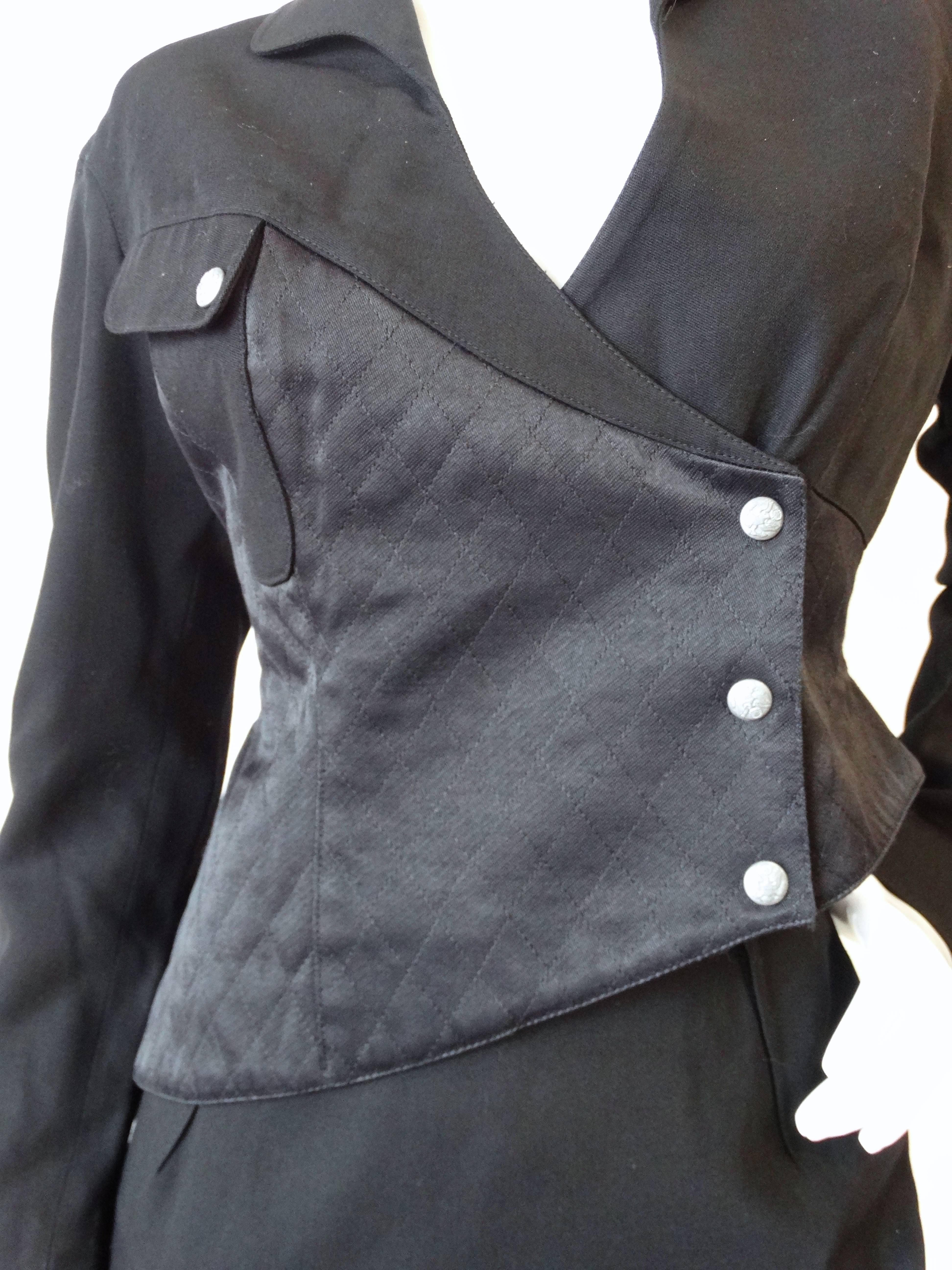 High fashion meets workplace apparel in our incredible 1980s Thierry Mugler suit set! The construction of this jacket is amazing, thick black fabric contrasted with quilted satin. Asymmetrical hemline adds some futuristic flair. Silver snap buttons