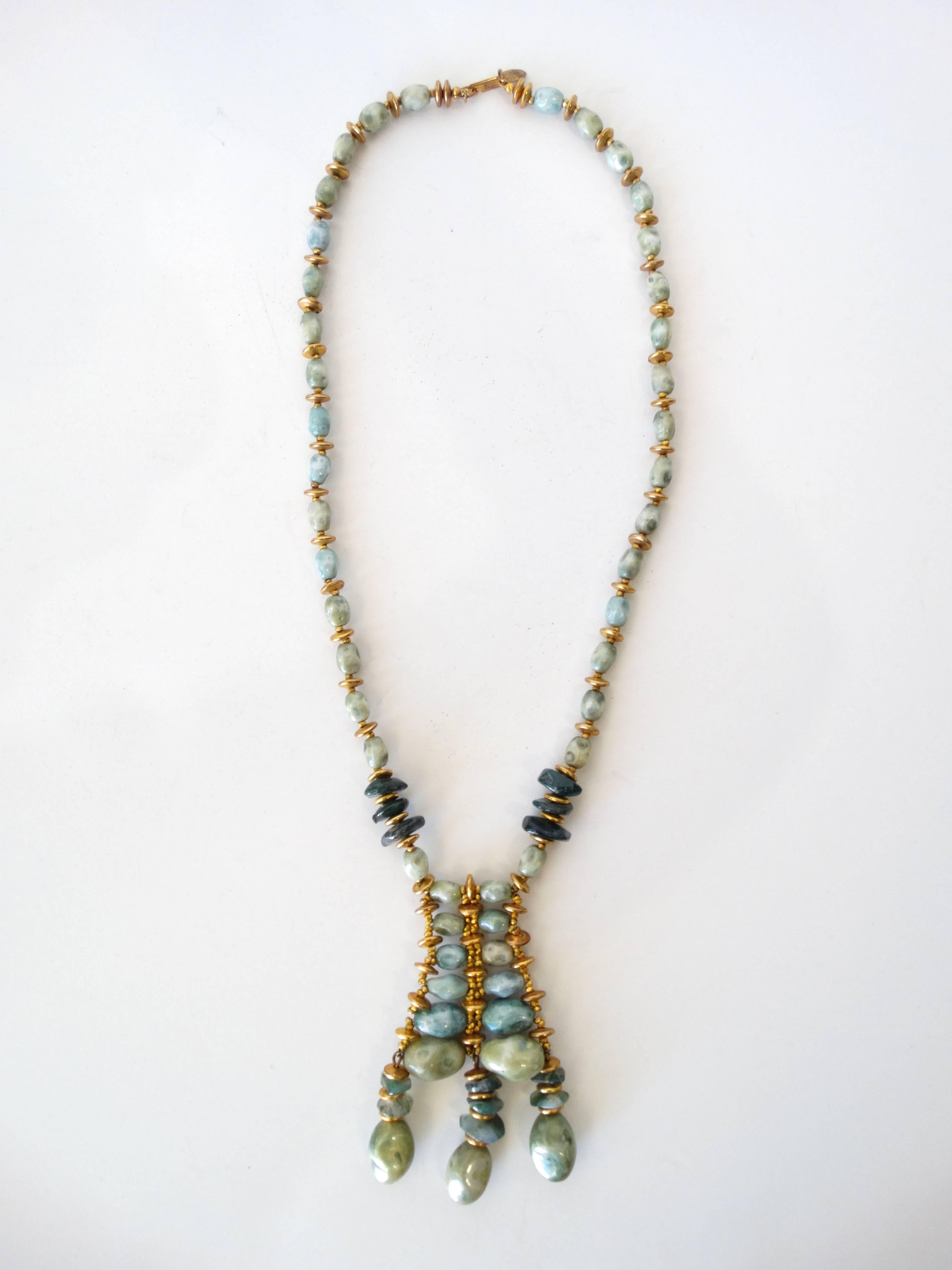Incredible stone necklace from iconic jewelry designer from Miriam Haskell! Single strand necklace beaded with green and gold toned beads. Comes down to intricate bead pendant, crafted from the same stones and gold beads, accented with three drop