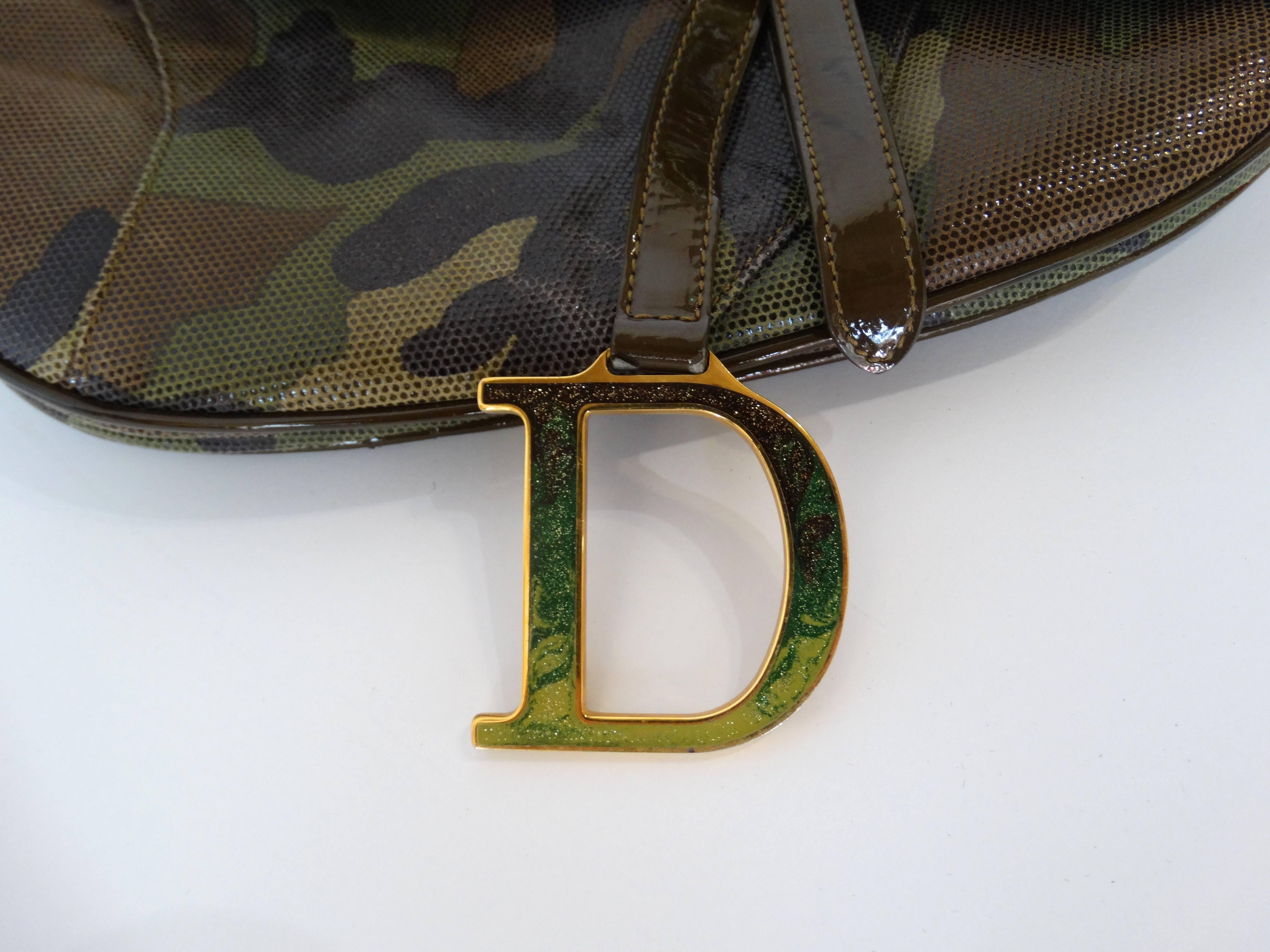 Christian Dior saddle bags are back in a big way! Here's your chance to nab yourself a saddle bag in the rare camouflage color-way! Made of a glossy mesh embossed camo printed leather. Hidden velcro closure beneath the top flap. Gold CD metal strap