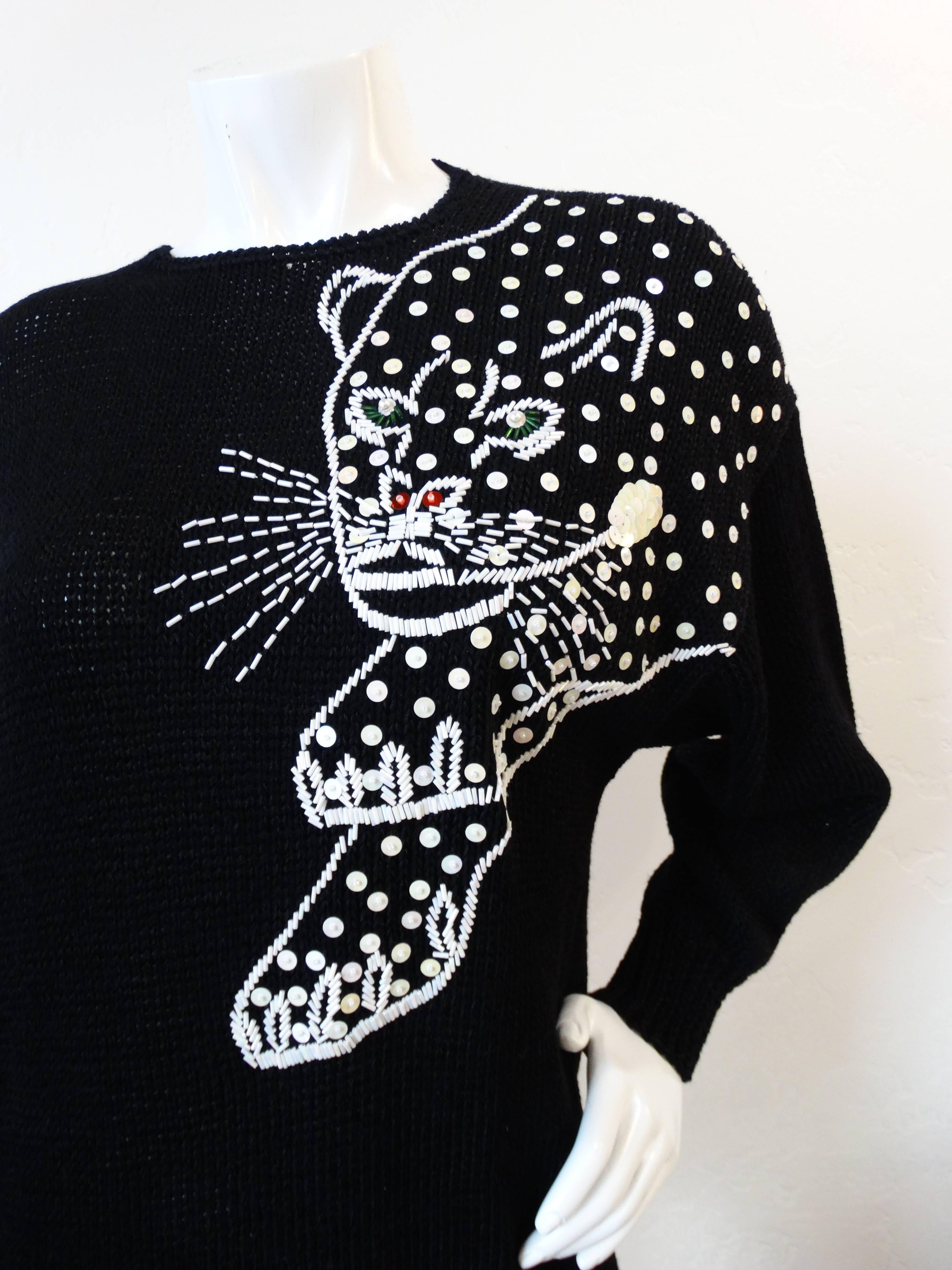 The best of 1980s style in one piece: jungle cat motifs and sequins! Soft solid black knit sweater with a flattering dolman style fit. Jaguar motif on the left shoulder made up of little iridescent sequins and beads.  Elasticized banded waist and