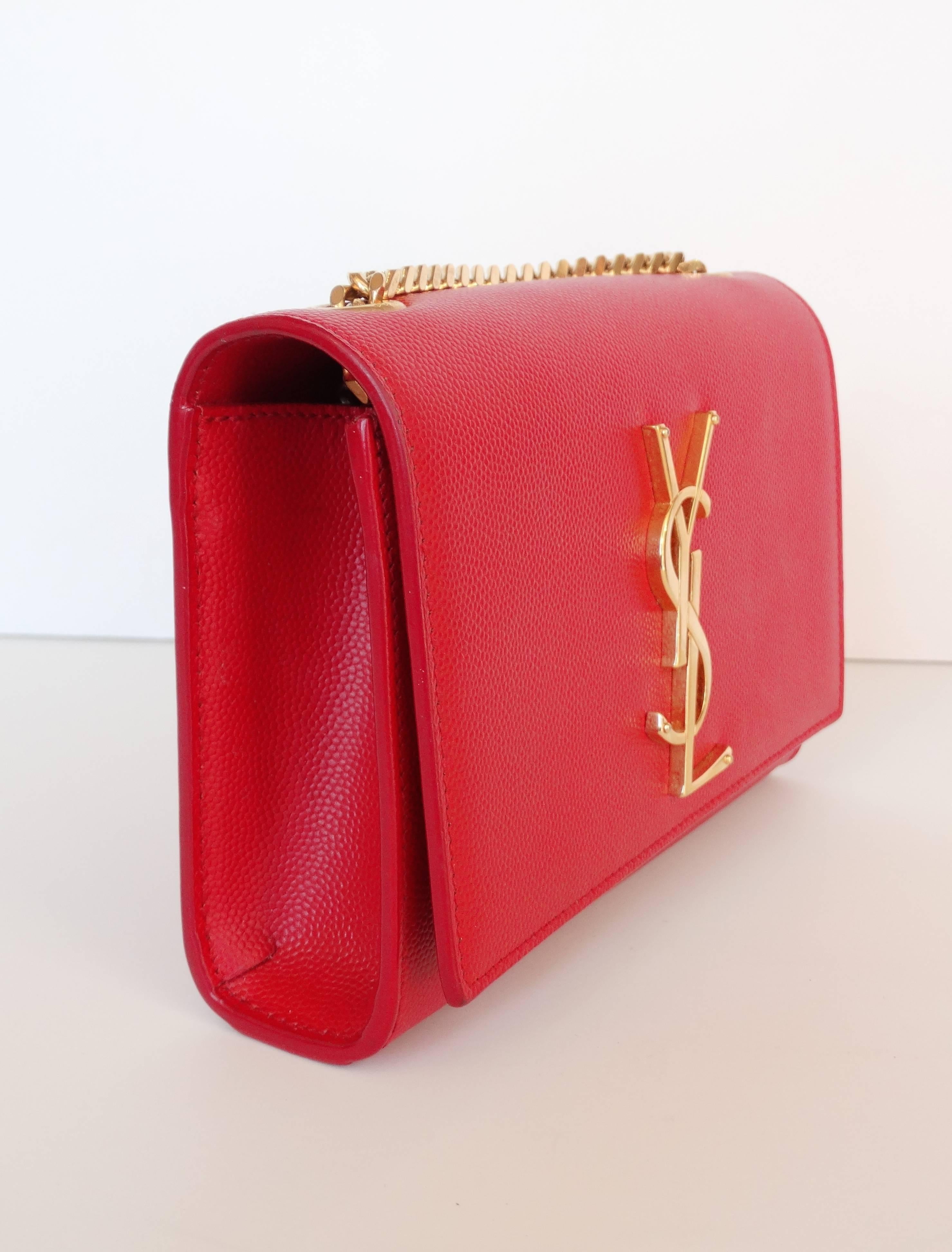 Your perfect evening bag has landed! Add a pop of color to your looks with our Yves Saint Laurent cross-body bag! Made of a quality solid red leather accented with contrasting gold metal accents. YSL metal accent on the front of the bag with