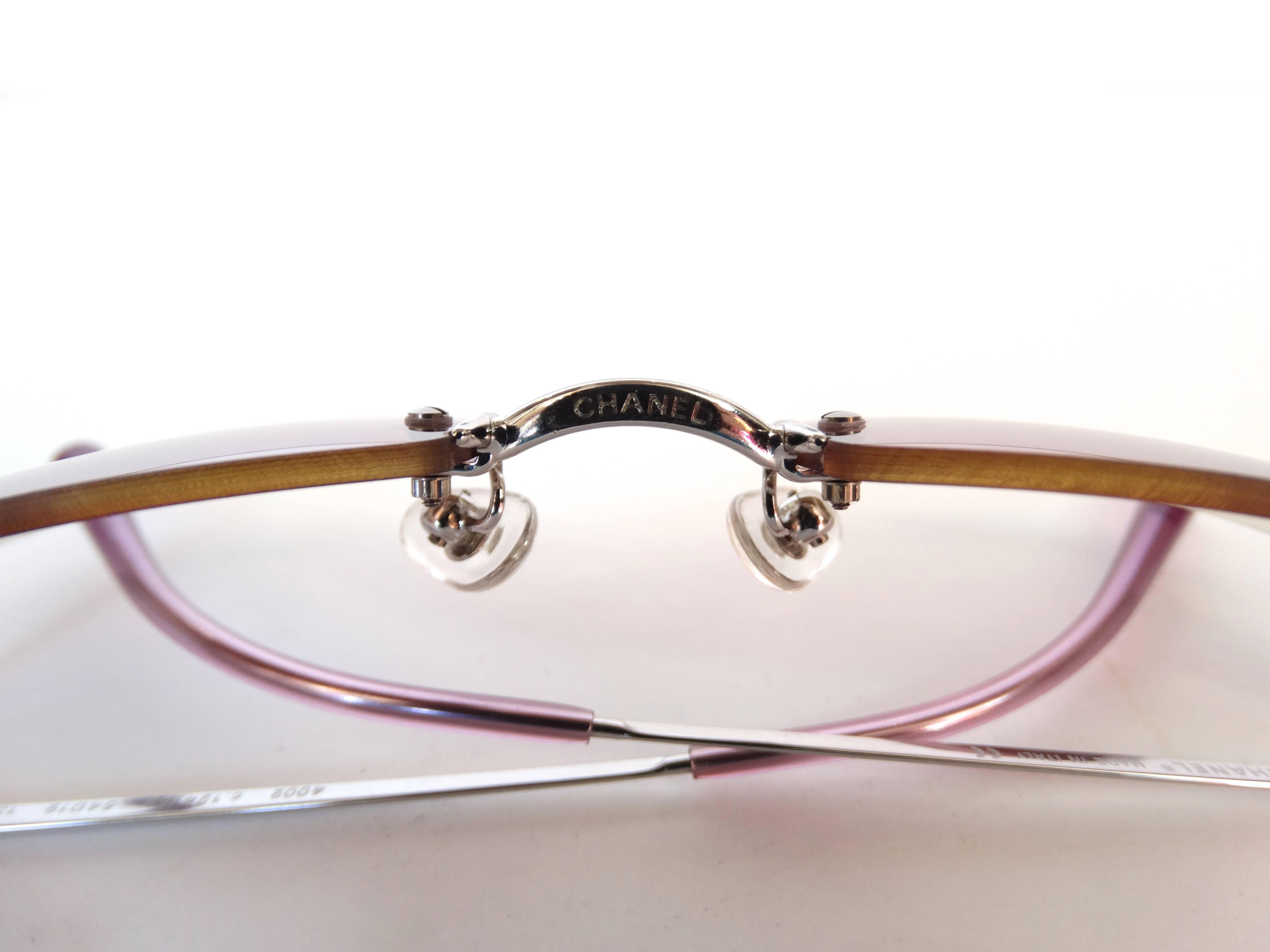 Channel the golden age of monogram fashion in our early 2000s Chanel sunglasses! Light pink-purple ombre glass lenses accented with small silver CC embellishments on the sides. Thin silver wire arms with Chanel signed on the inside. Clear nose pads.