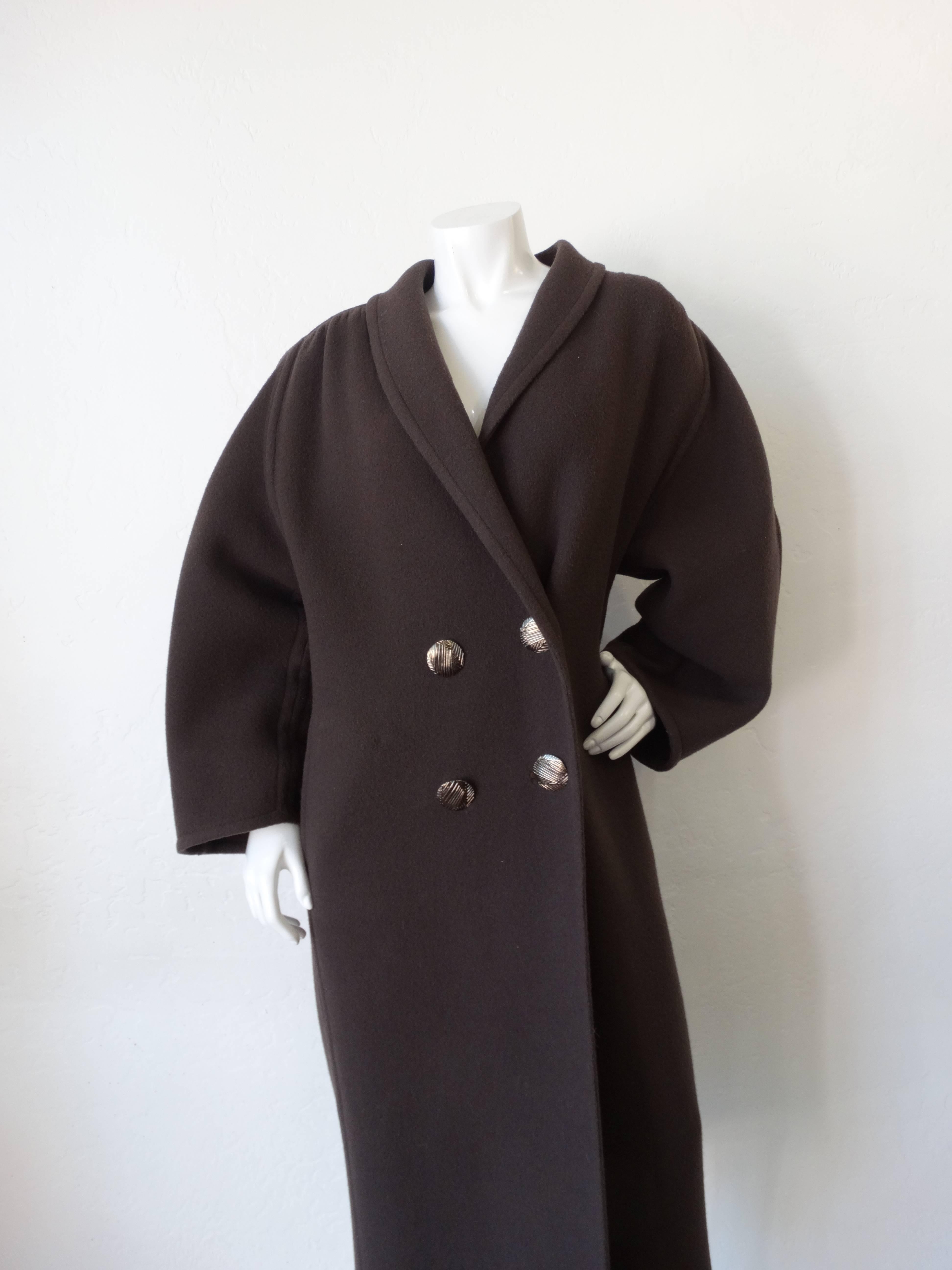 We are obsessing over this incredible 1980s Galanos coat! Super chic oversized silhouette with shapely sleeves and detailed back. Made of a super soft wooly blend fabric in a cool dark grey color. Double breasted construction, fastens with four