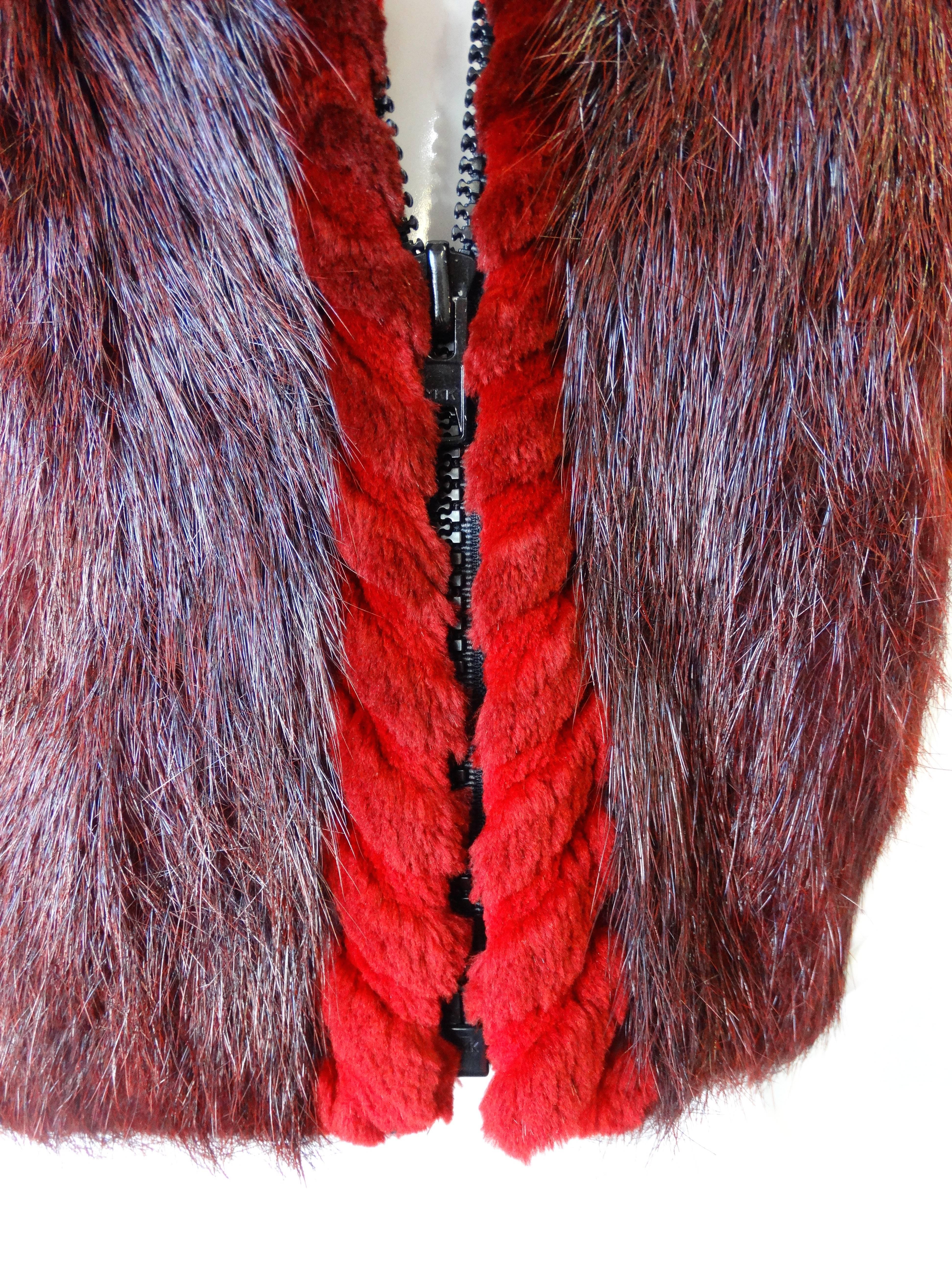 Incredible 1990s beaver fur vest from Alaskan furrier David Green! Made of a super dense and soft burgundy hued beaver accented with bright red sheered beaver trim all along the edges of the vest. 
Hidden pockets at either side of the waist. Zips