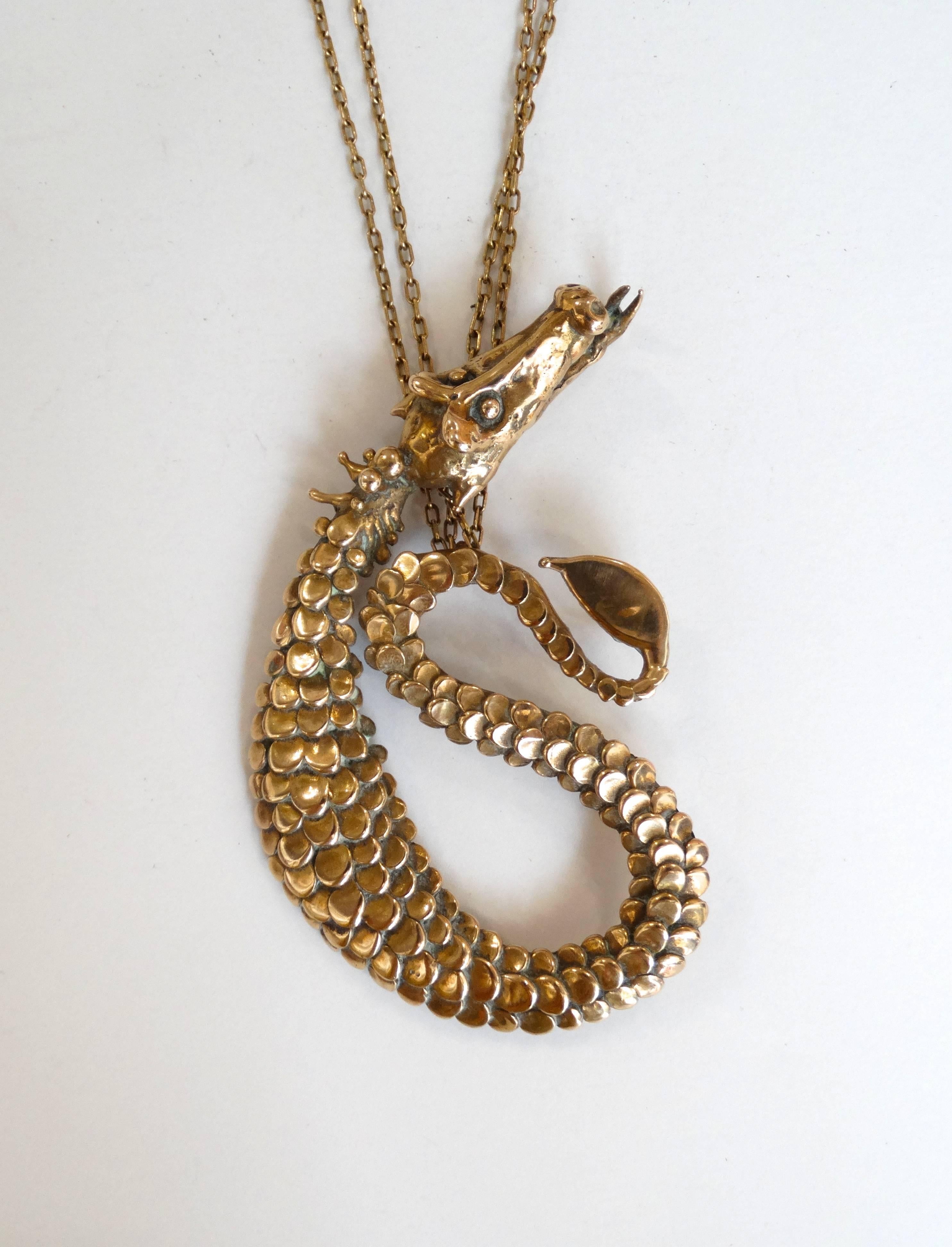 Channel your inner fire with our incredible Carl Tasha Dragon pendant necklace! Heavy quality brass metal carved intricately to look like a wingless dragon. Detailed scalloped scales add dimension to this incredible piece. Double layered thin chain.