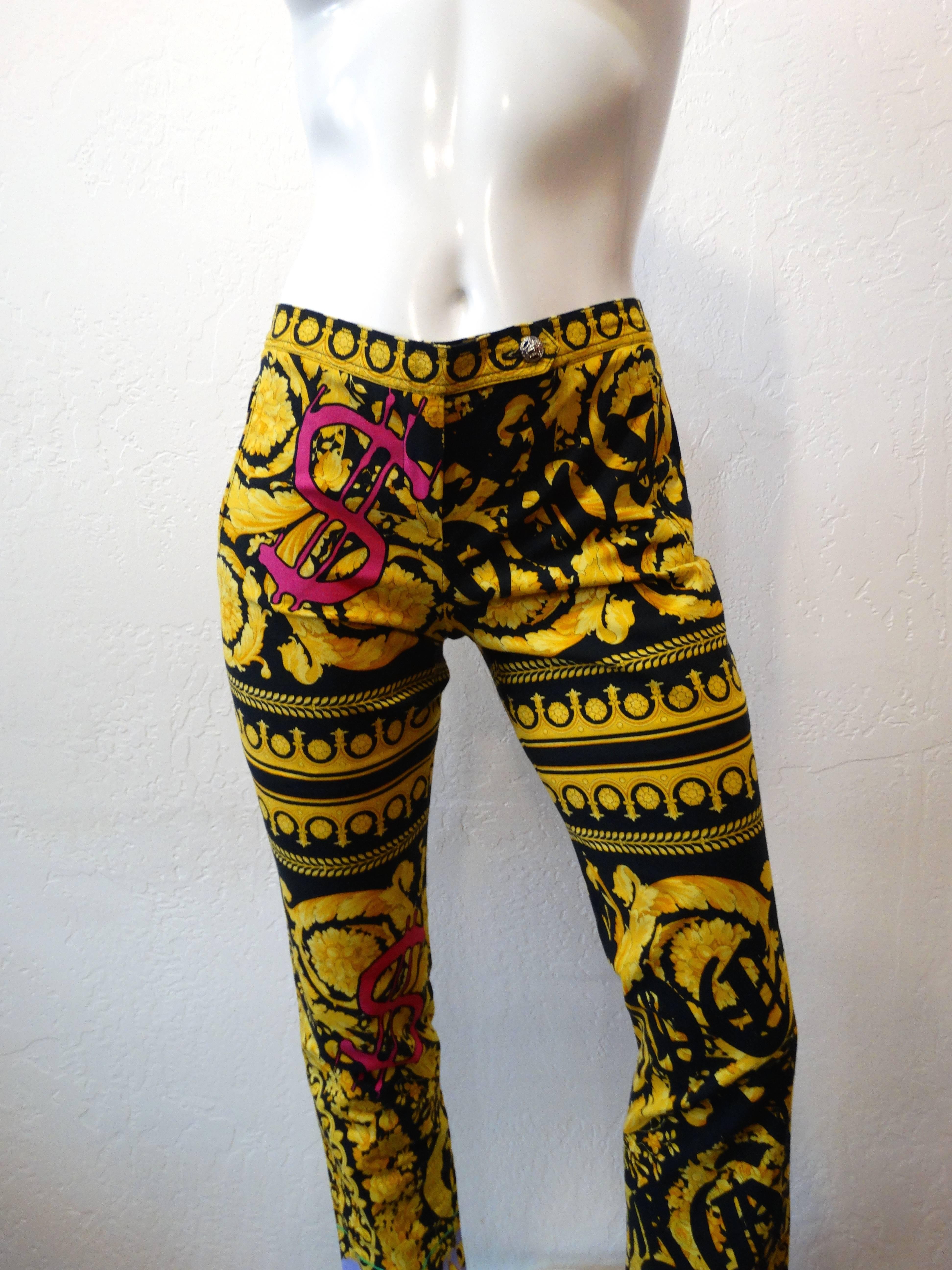 Channel your inner wild child with our 1990s Versace printed pants! Woven cotton printed all over in black and gold classic Versace baroque pattern accented with pink, green, and lavender graffiti inspired designs. Mid rise fit with tapered leg fit.