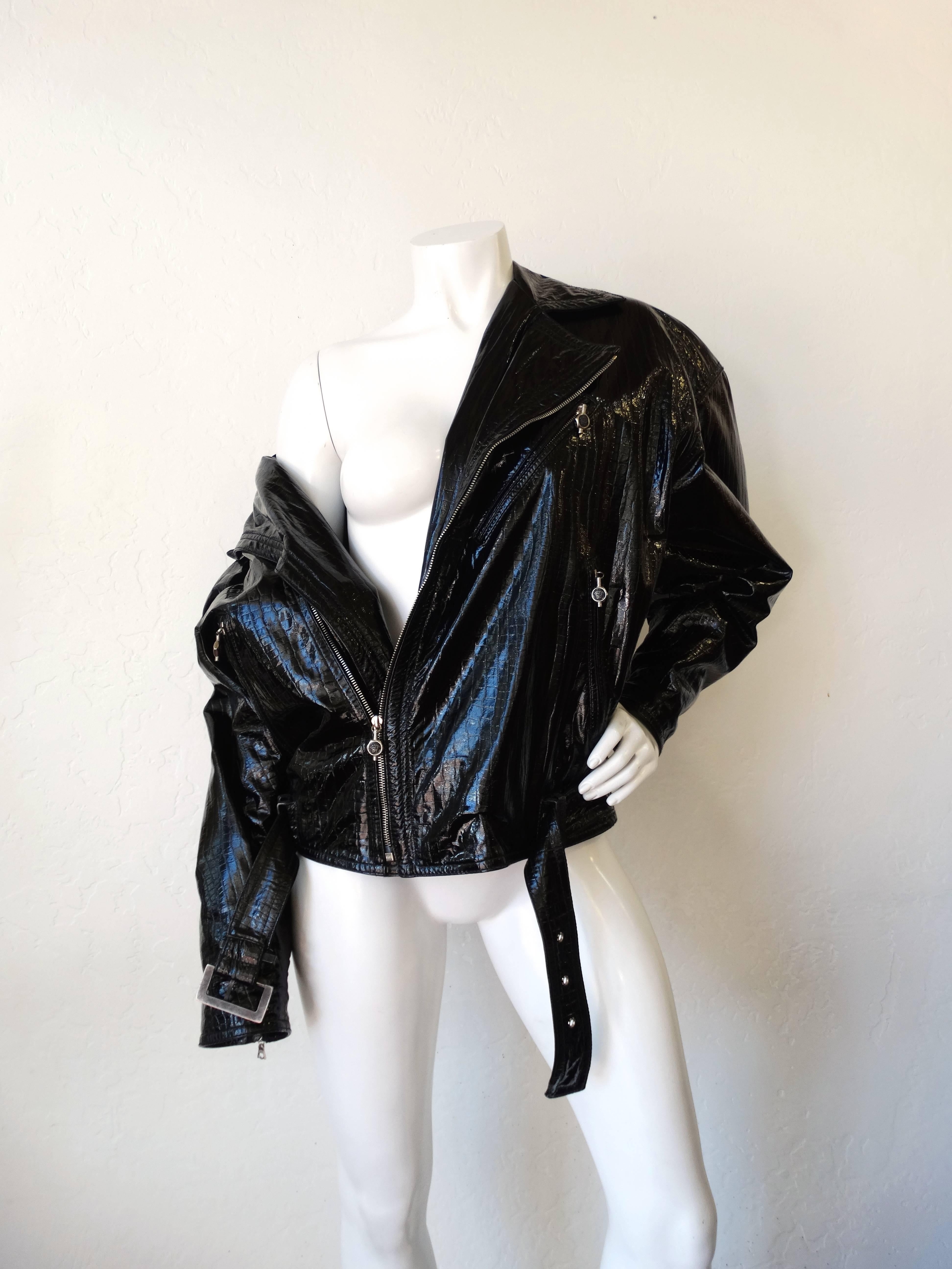 Offrez-vous une pièce emblématique de Versace des années 1980 avec notre incroyable veste de moto en cuir verni ! Réalisé en cuir verni super brillant, gaufré à l'alligator, et doublé d'un imprimé de tête de méduse Versace en rayonne dorée ! Veste