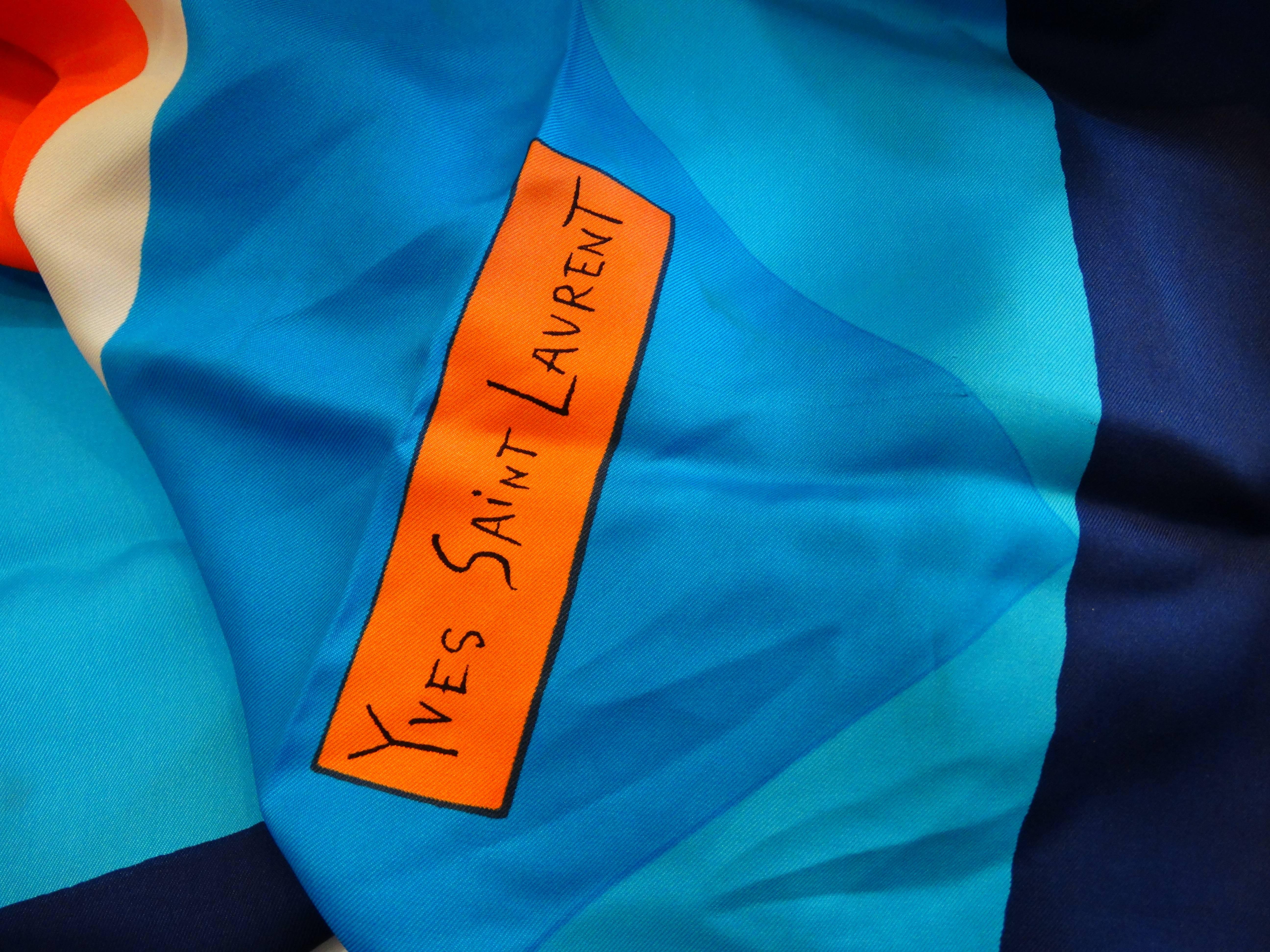 This amazing 1960s Yves Saint Laurent scarf evokes the work of Josef Albers- with contrasting coral and blue colors in geometric blocks throughout the print of the piece. This piece is versatile! Wear it as a headscarf, knotted as an ascot, or tie
