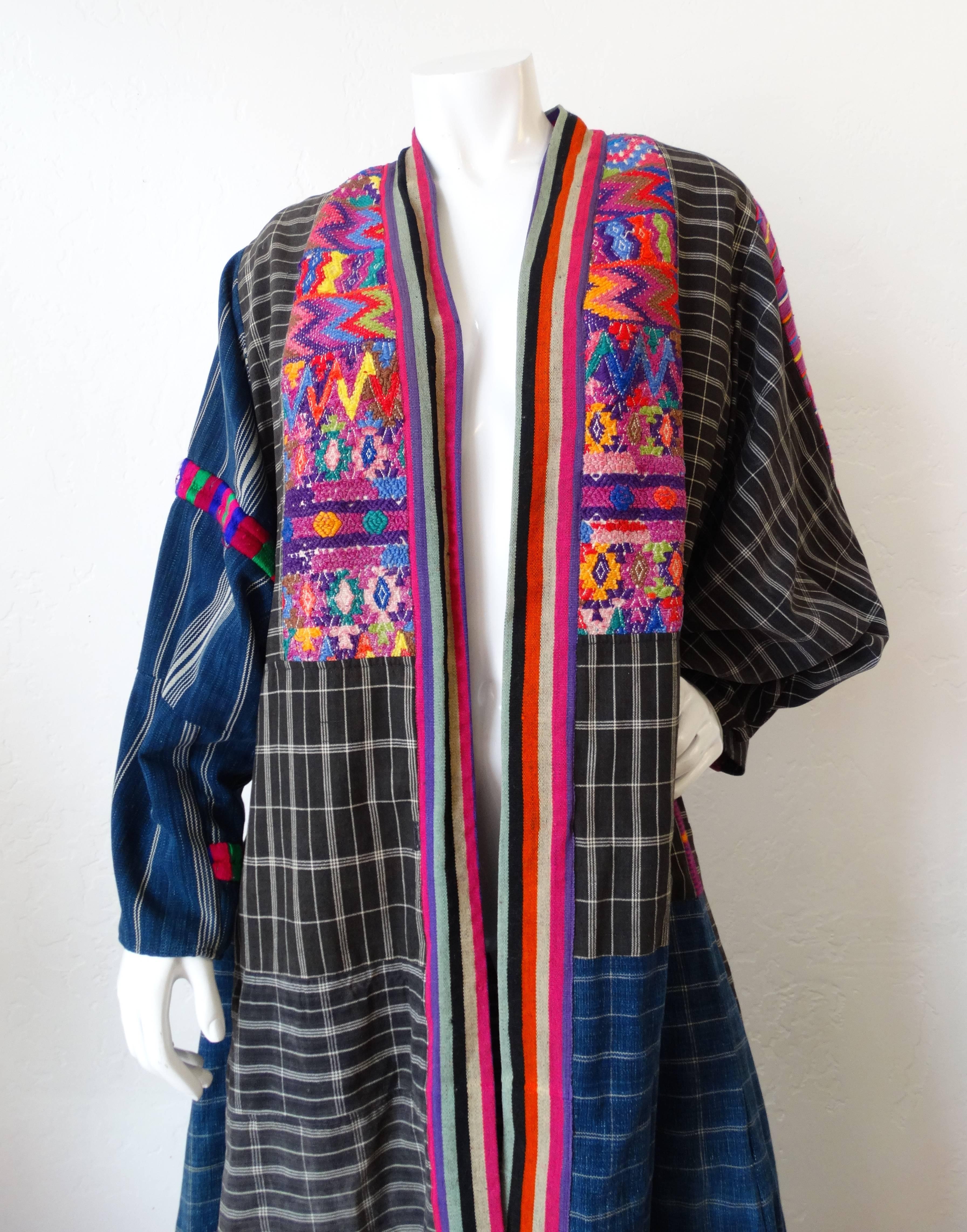 Amazing 1970s embroidered duster jacket made of Guatemalan fabric! Contrasting grey and blue, striped and plaid prints. Accented with panels of multicolored embroidery around the neckline. Oversized sleeves and long duster length. Has a vest with