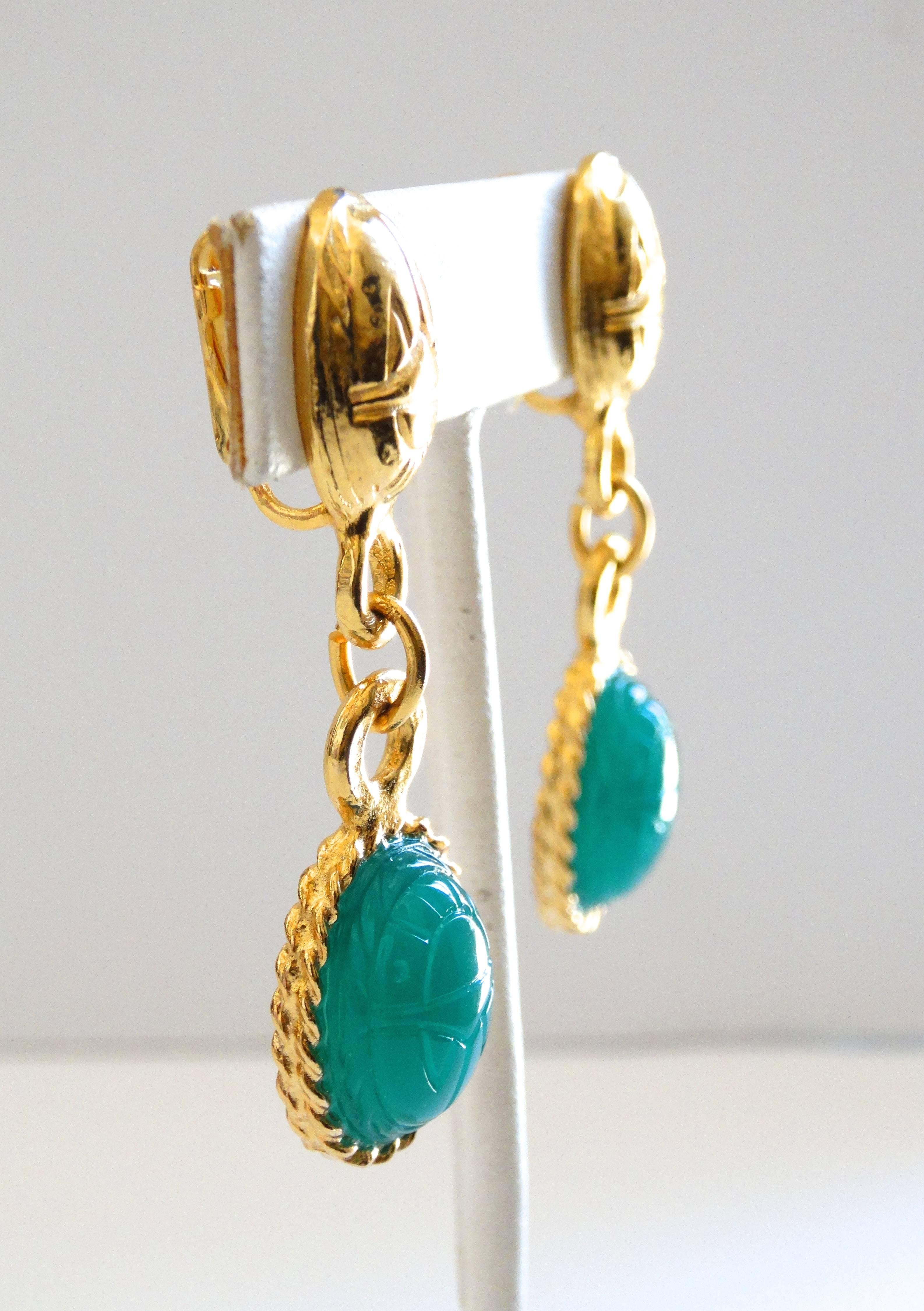 Amazing vintage Kenneth J Lane dangly earrings! Gold metal jewel scarab beetle style post with contrasting beetle charm in a semi-translucent green. Clip on backs. Signed Kenneth J Lane on the backs of each earring. 


Length:  2 in 
Width: .5 in 