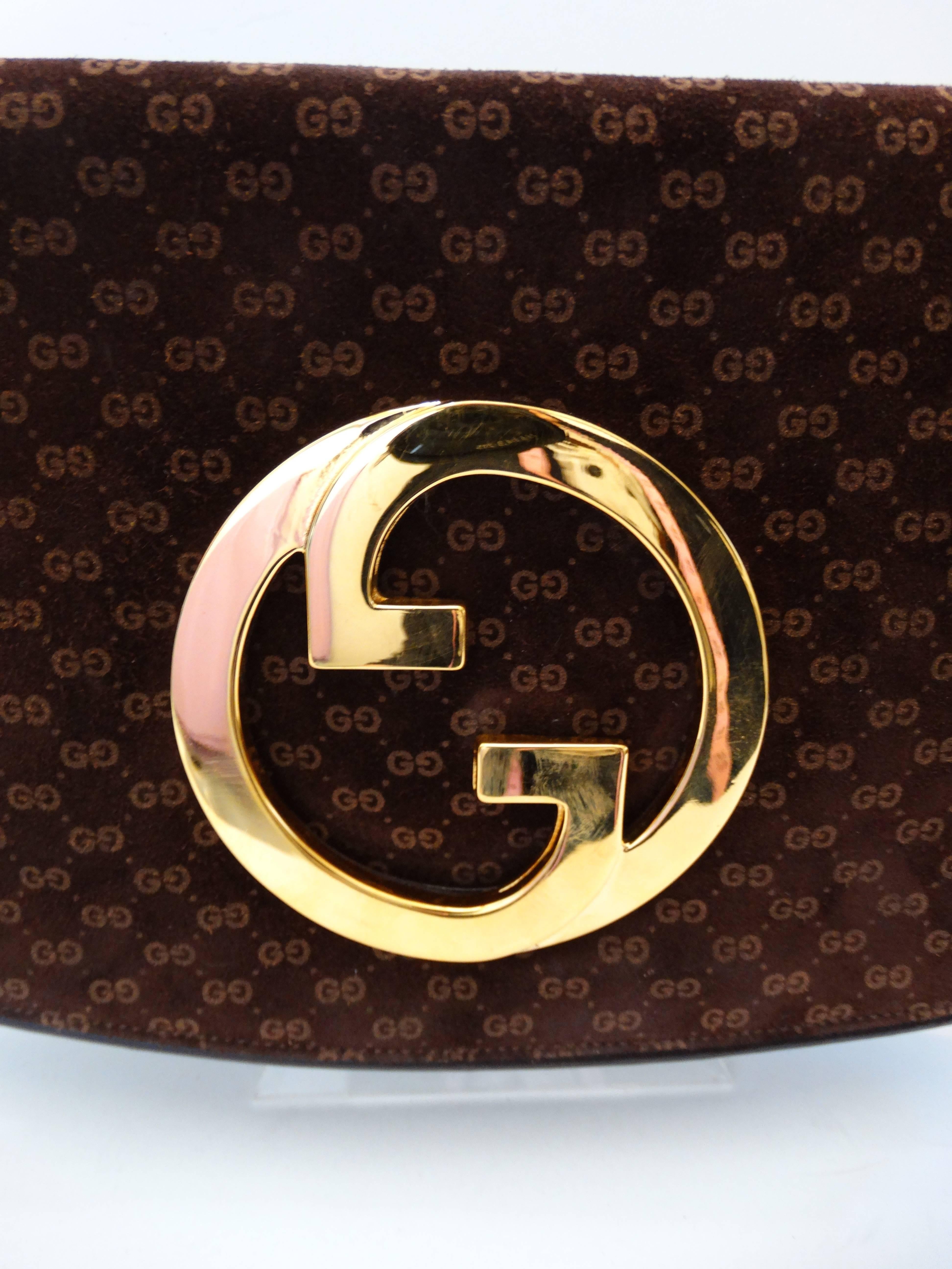 Amazing monogram suede Gucci clutch circa 1972! Made of a super soft brown suede covered in the signature Gucci monogram all over print! Cut out style GG emblem in a shiny gold metal. Brown leather interior signed with Gucci, Made in Italy. Fold