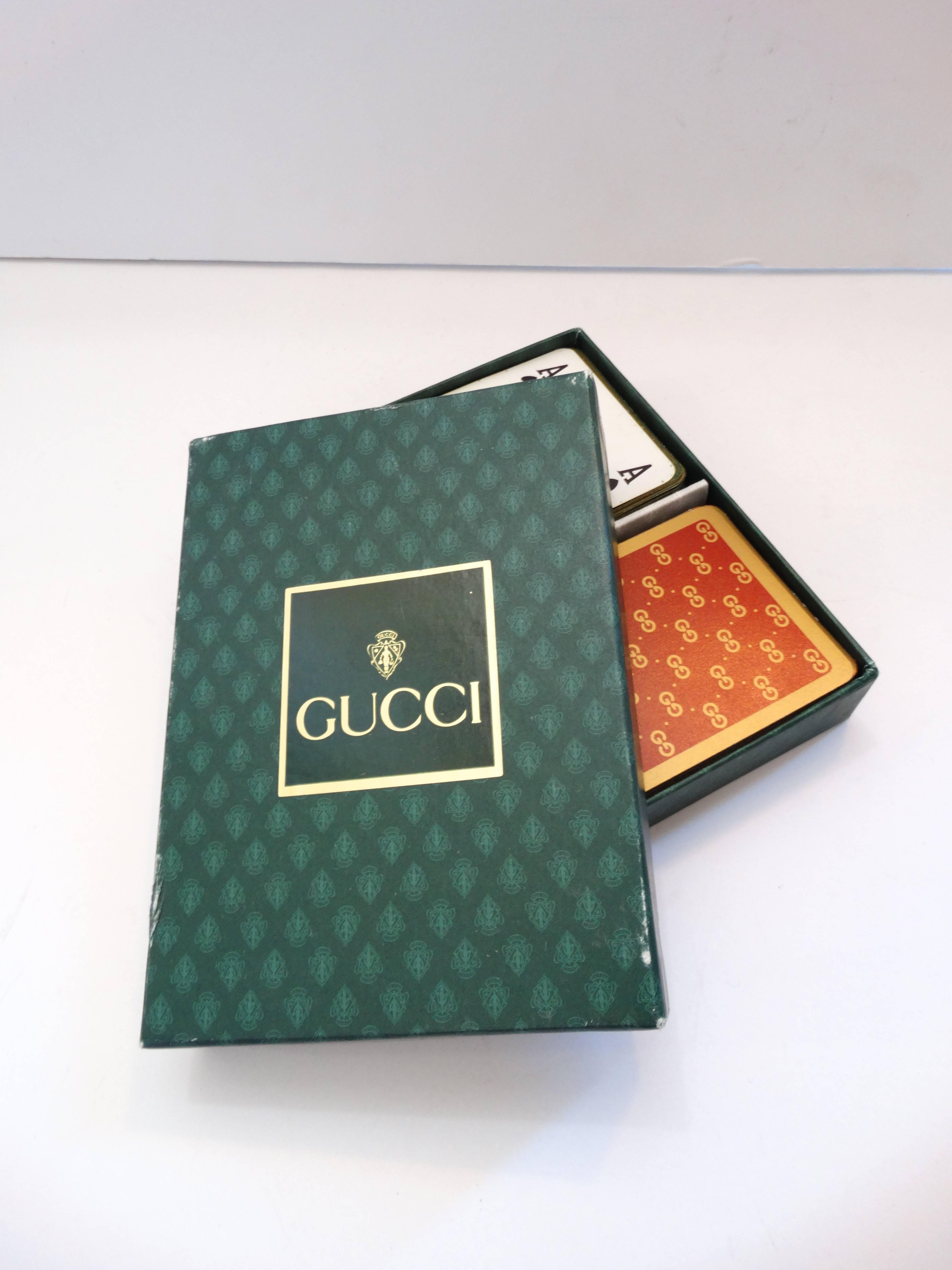 Aces up! Up your ante with our stylish 1970s Gucci monogram playing card set! Comes with two full sets of playing cards, one in red and one in green- both accented with gold Gucci monogram print and gold trim. Comes with original Gucci printed box