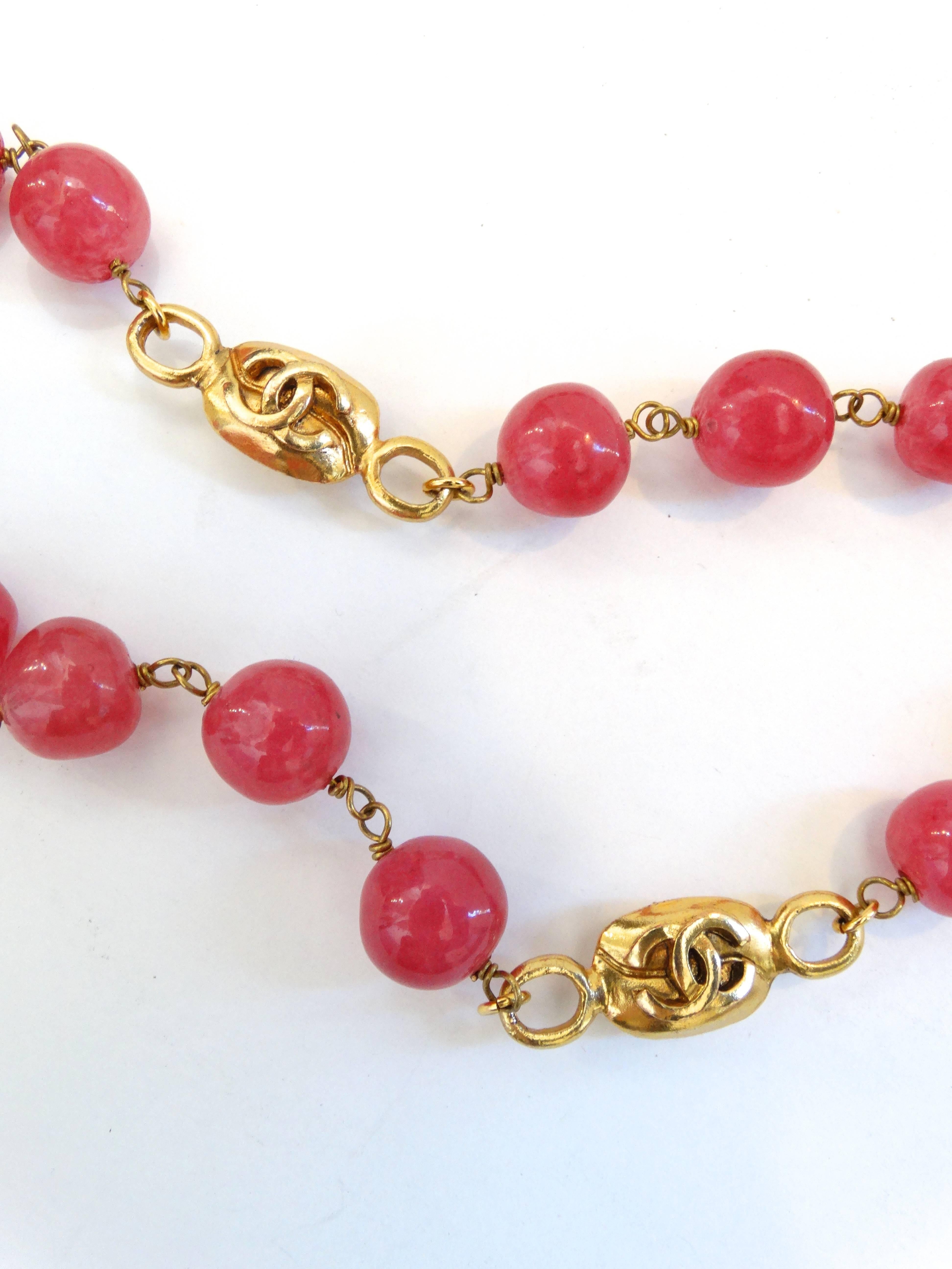 The most elegant strand necklace from Chanel circa 1997! Made of glossy pink Gripoix glass beads with gold chain hardware and CC monogram charms throughout the entire necklace. Looks great worn as a single strand or doubled up around the neck. Hook