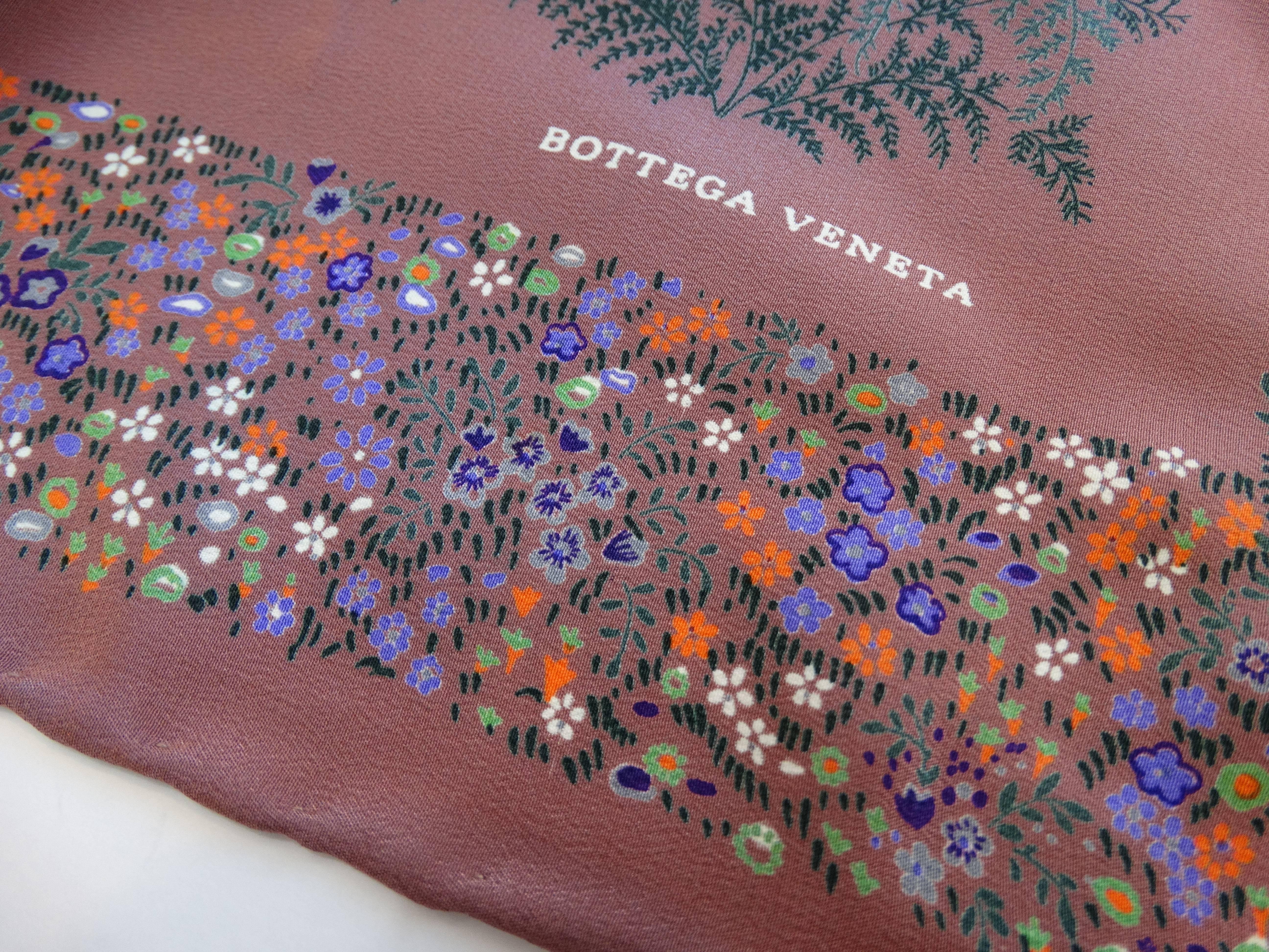 Amazing floral printed scarf from designer Bottega Veneta! Amazing mauve colored silk printed with intricate ditsy florals and an image of a woman coming out of the water in the center. Accented with dreamy sunset colors, pale oranges and yellows.