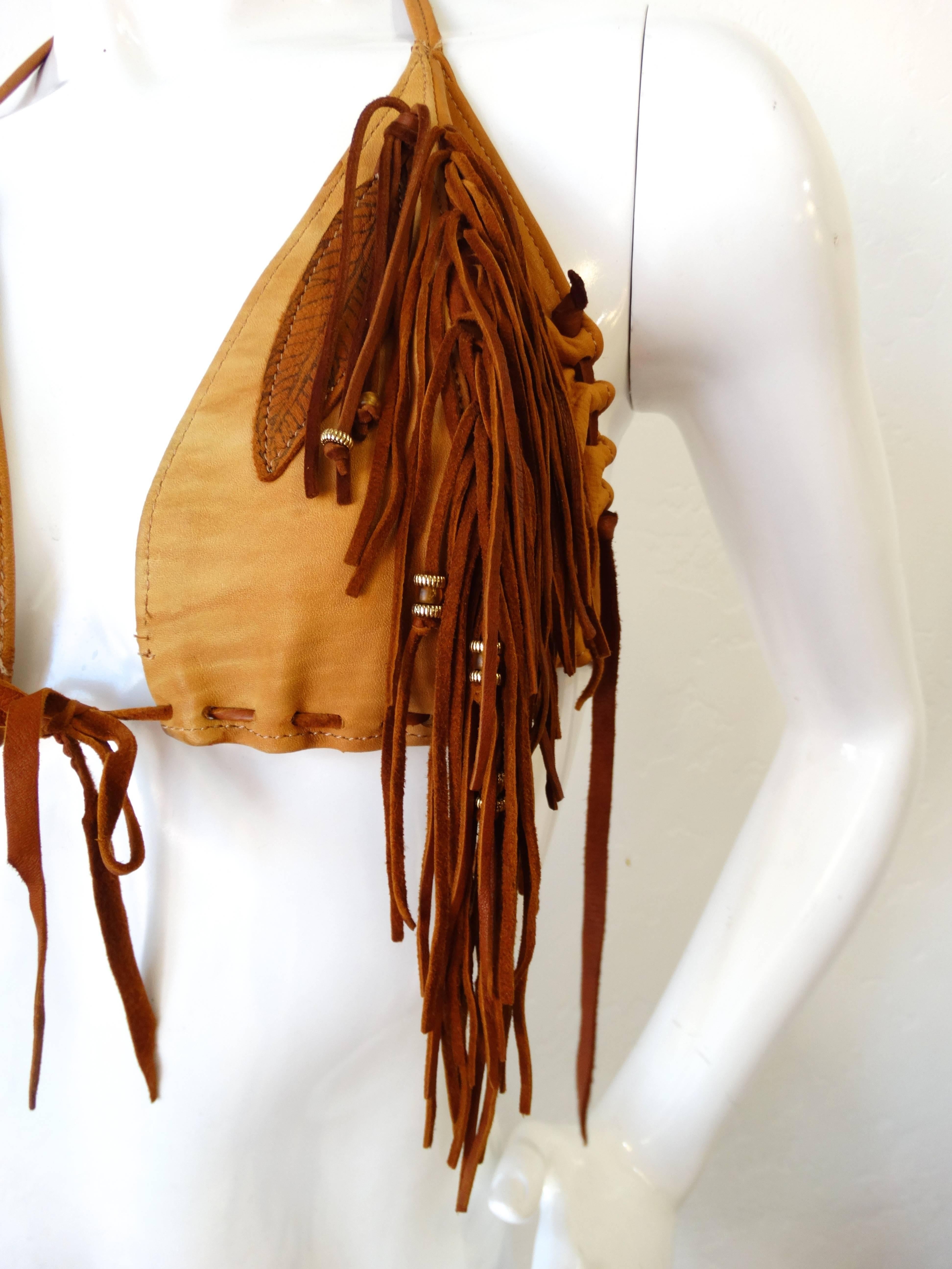 Channel the spirit of the 1970s (with a western twist) with our amazing suede bikini top! Tan leather topped with brown suede fringe down each of the cups. Halter neckline, fastens in the back. Adjustable fit, comfortable fits about a B Cup. 