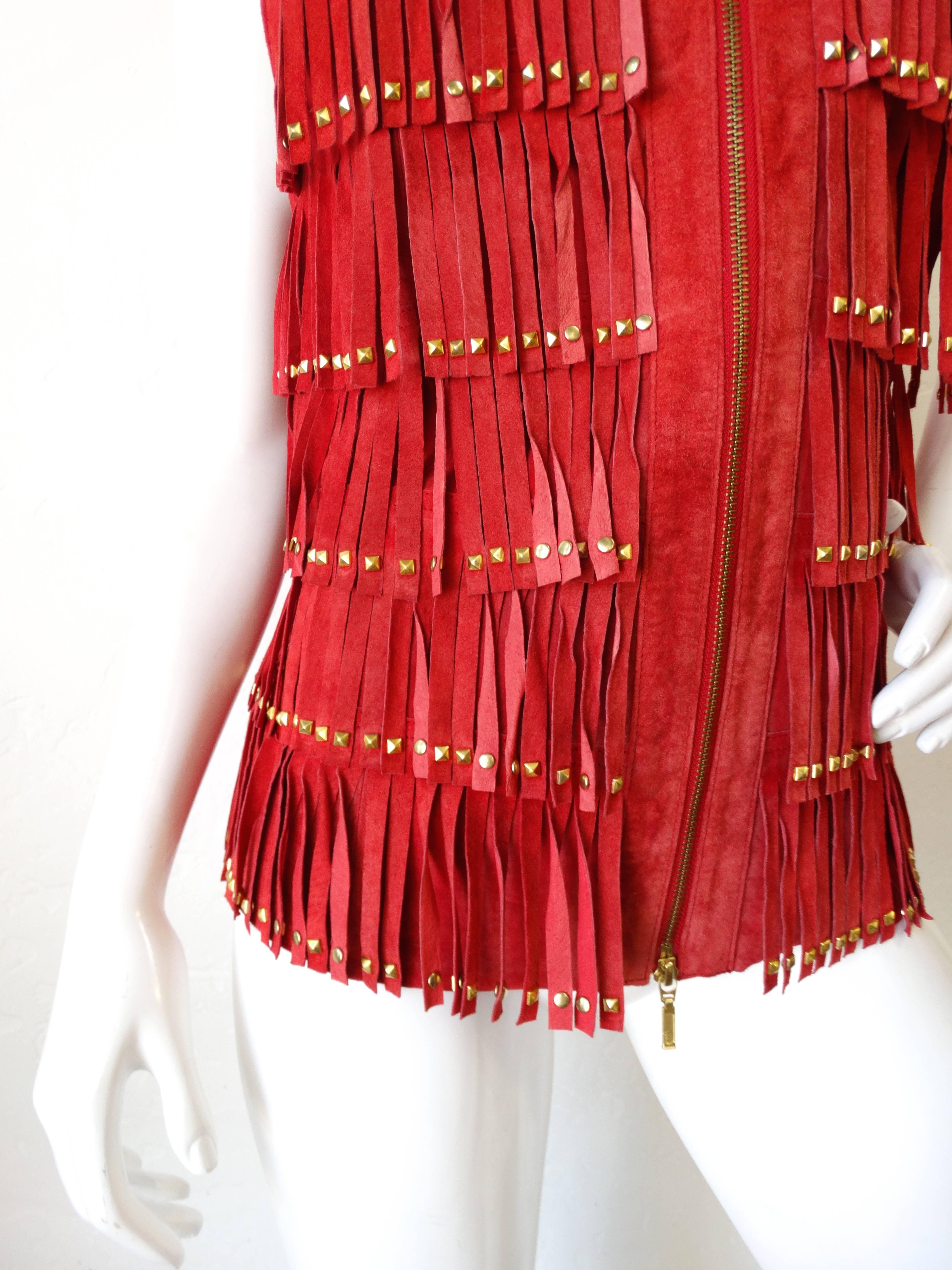 Get ready for festival season with our adorable red suede fringe vest! Made of a super soft suede in a bright lipstick red color. Fringe all down the front of the body, accented with flat head studs at the end of each piece. Zips up the front of the