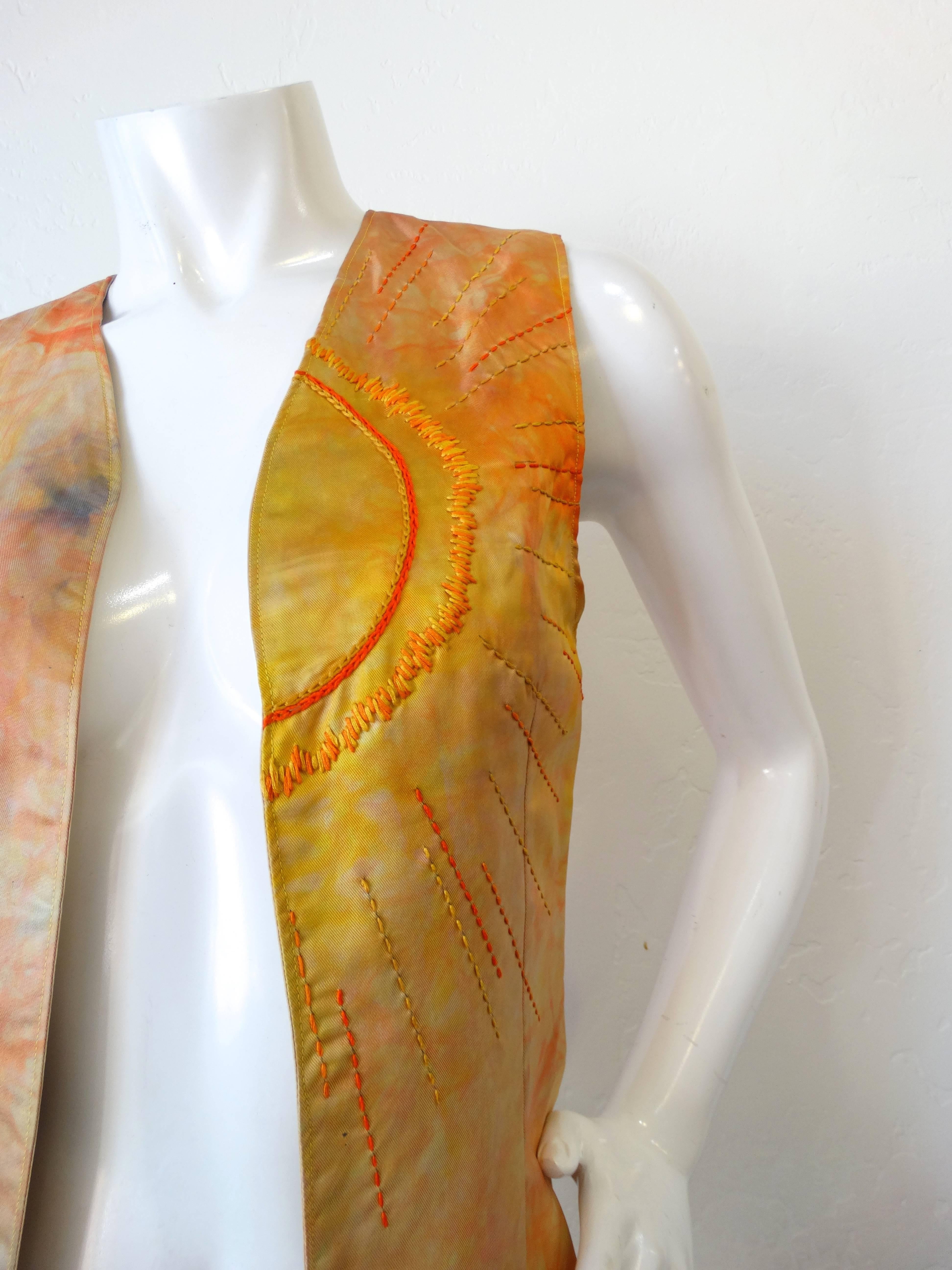 Channel the spirit of the 1970s this festival season with our amazing silk vest! Constructed of a soft silk fabric, tie-dyed in hues of orange, yellow and blue. Classic vest silhouette with open fit. Embroidered with a Sun motif on the left side in