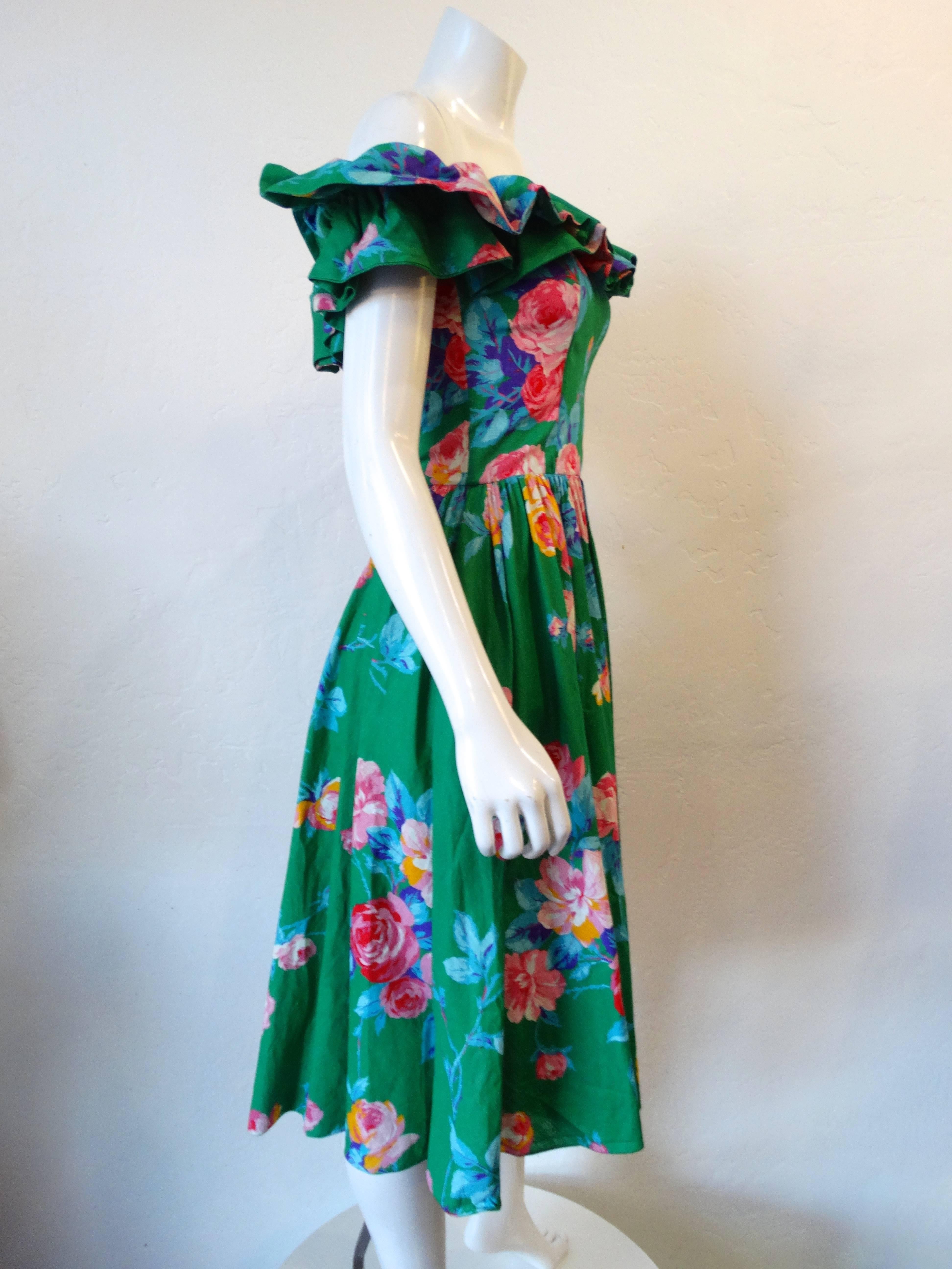1980s does 1950s silhouette with our dress from S.G. Gilbert. This flirty little number features a bold colorful floral rose print in green, pink, blue and yellow. Ruffled neckline, can be worn off the shoulder. Boned bodice makes for a structured