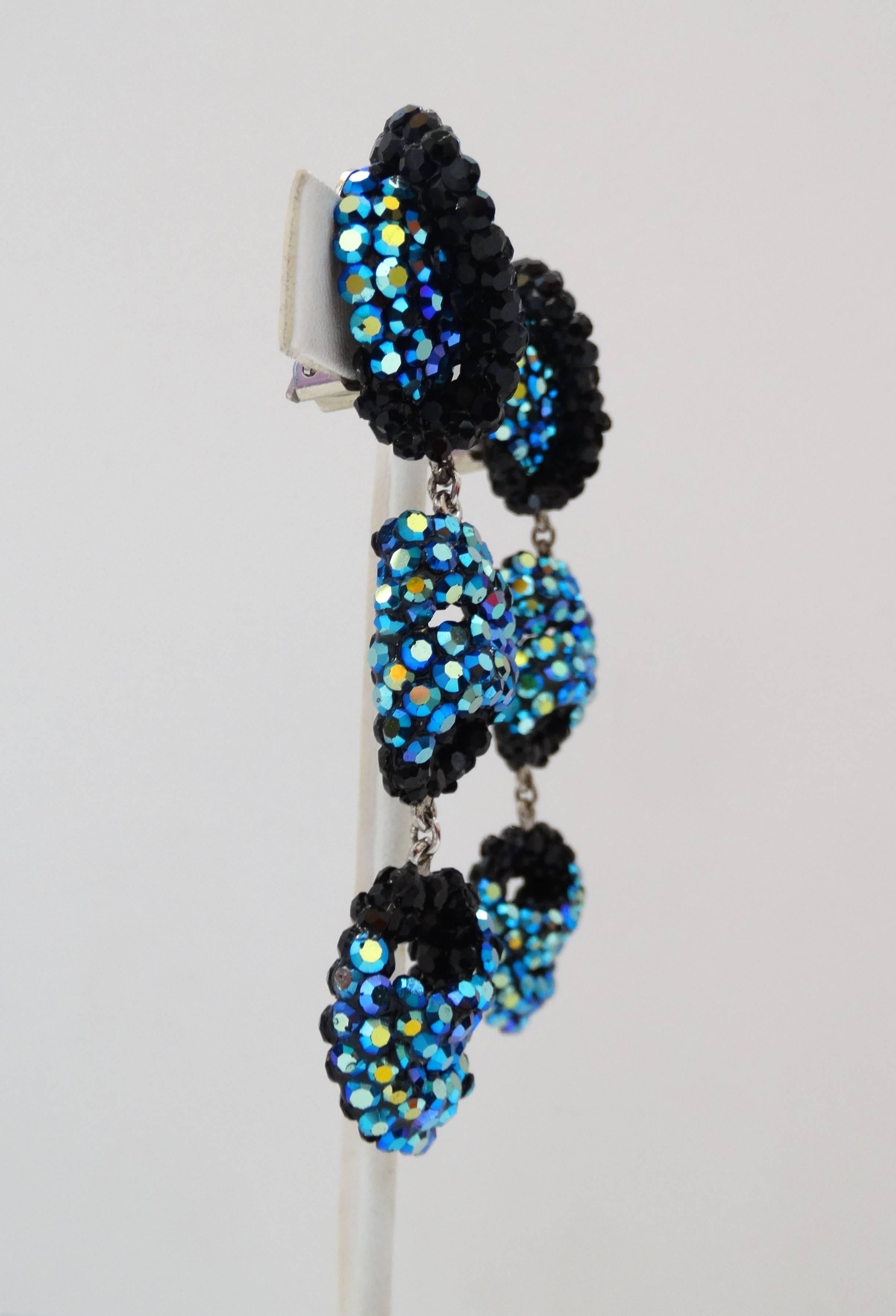 The most dazzling pair of avant garde, abstract earrings for your next cocktail attire occasion! Encrusted front and back with blue and black rhinestones throughout, three charms all attached with silver metal hardware. Clip on backs. Unsigned, but