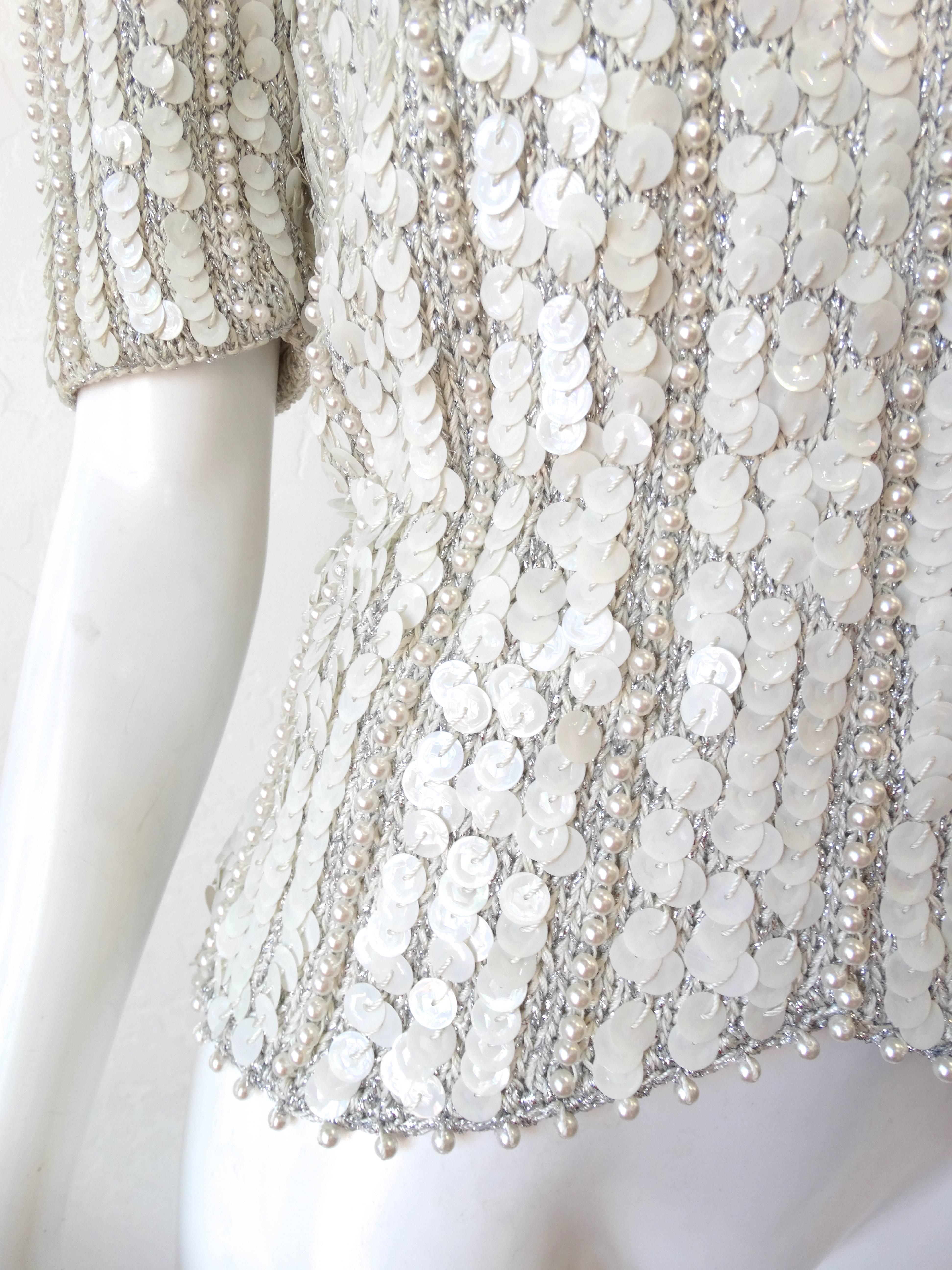 The perfect vintage meets glam sweater for your next evening out! Made of a white stretch knit fabric encrusted with stripes of large iridescent sequins and pearl beads. Strong shoulders, slightly padded-gives the illusion of an even smaller waist!