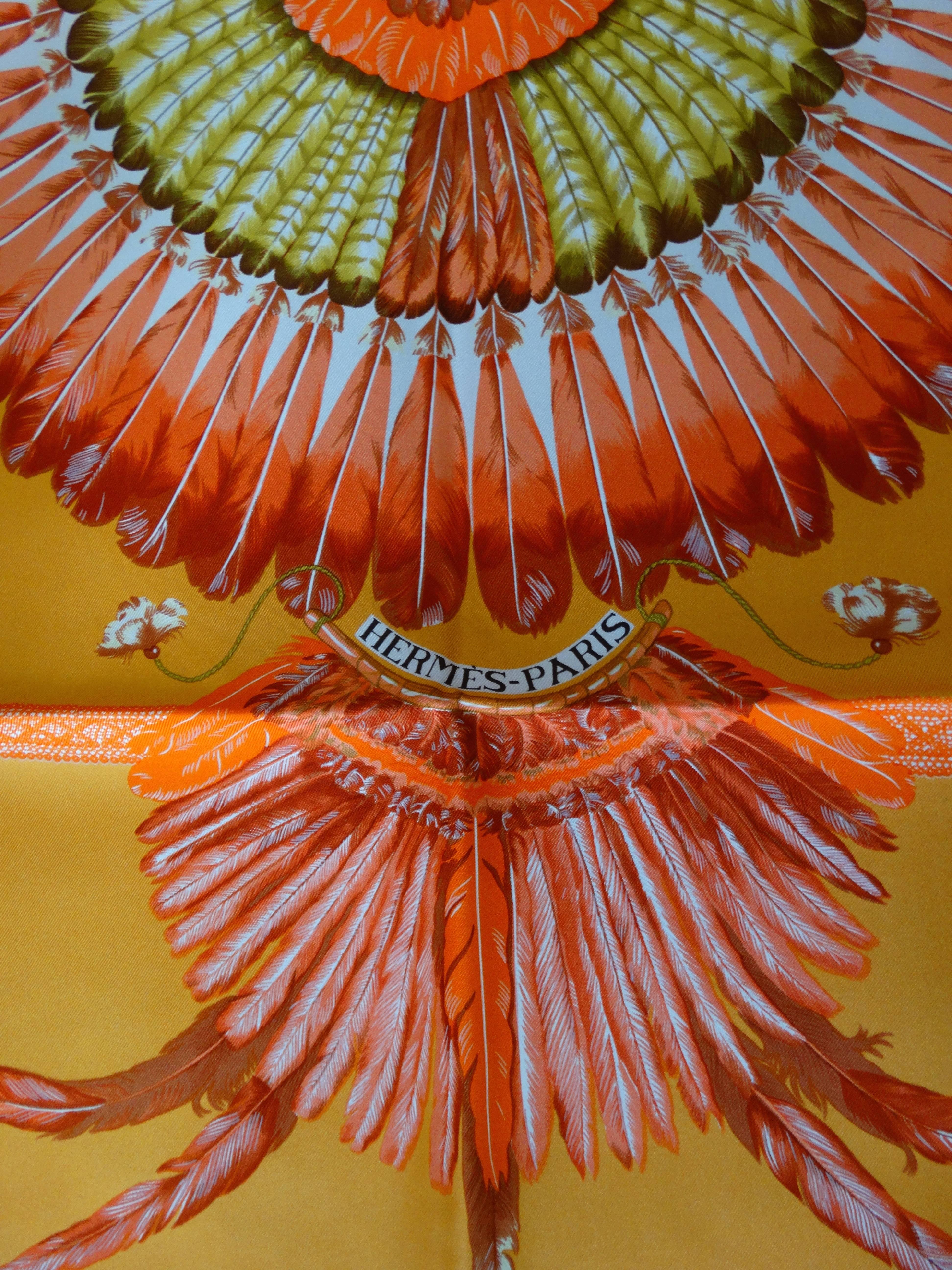 Amazing Hermes scarf in the coveted Brazil print! Bright orange silk with feather medallion print at the center. Accented with shades of red, yellow and white. Looks incredible as a headscarf, tied around the neck as an ascot- or even tied to the