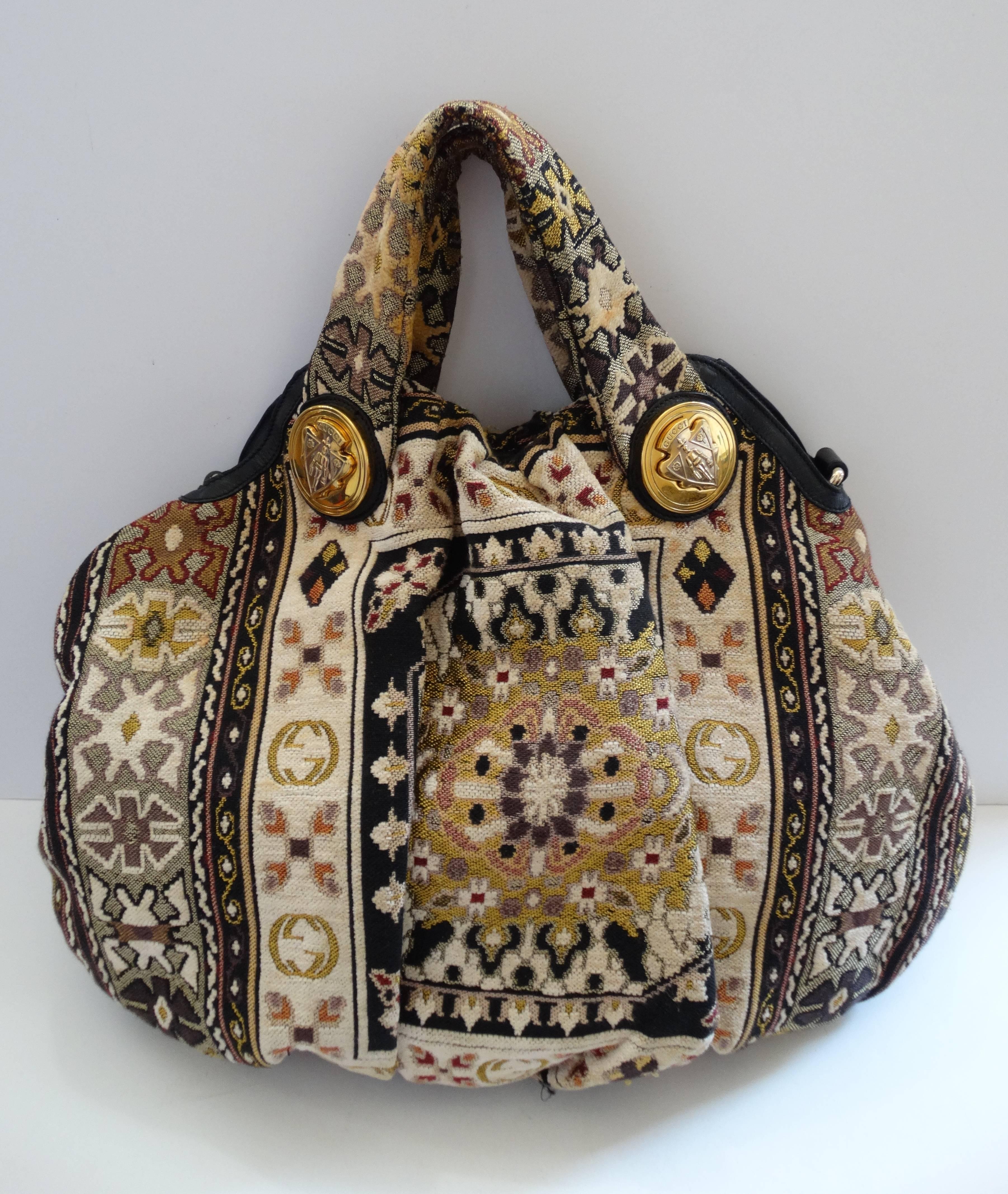 Get your Gucci on- with our adorable tapestry tote bag! Woven cotton tapestry Persian rug inspired print with Gucci G motifs throughout. Two Gucci medallions cast in gold metal on either side of the top handles. Two metal loops on either side, you