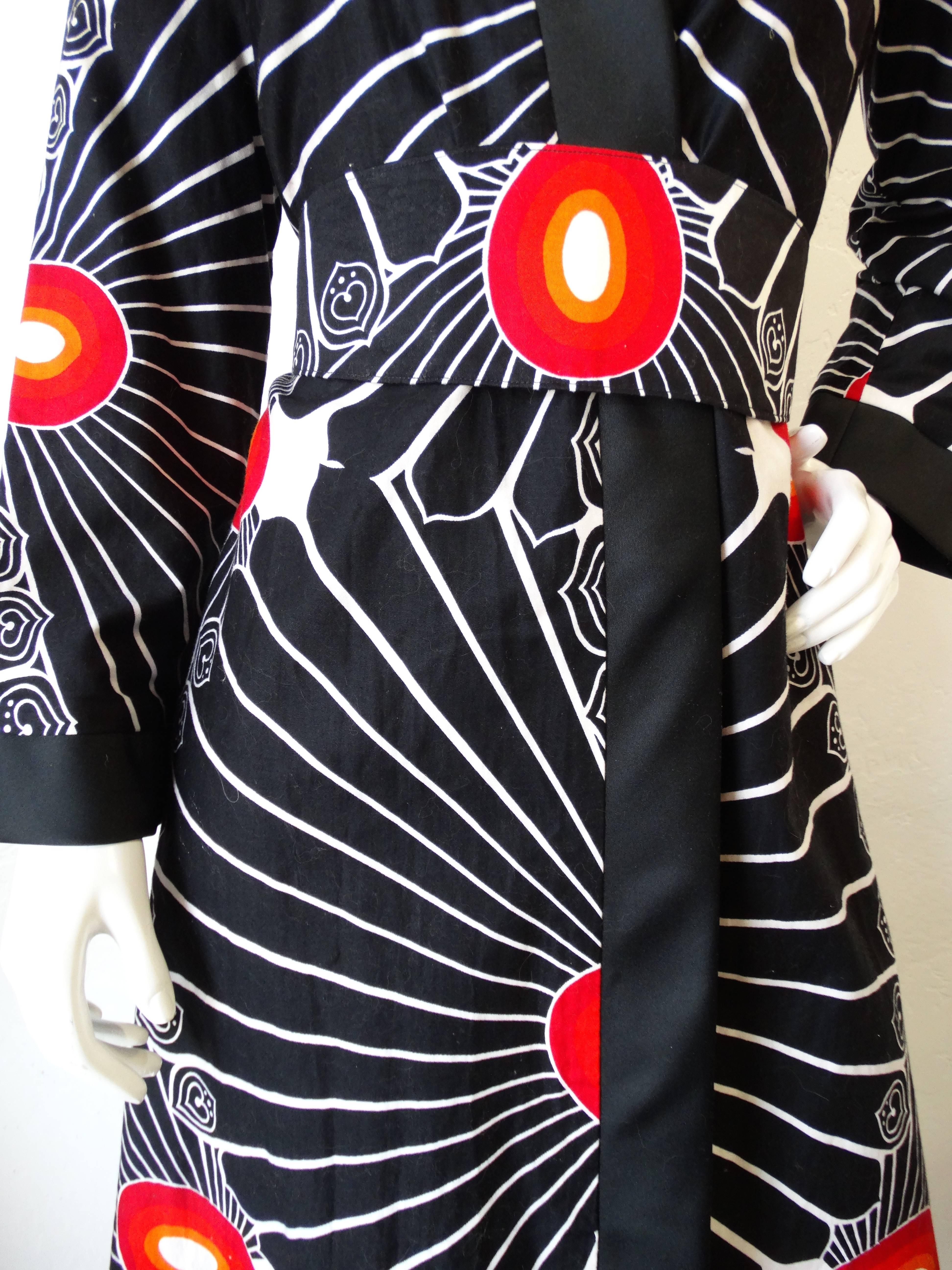 Incredible 1970s Chinese Kimono-like Robe from Barbara Lee Hong Kong. This piece has a breathtaking black and white print accented with red and orange sunburst like designs throughout on 100% cotton. Trimmed with solid black fabric. Obi sash ties