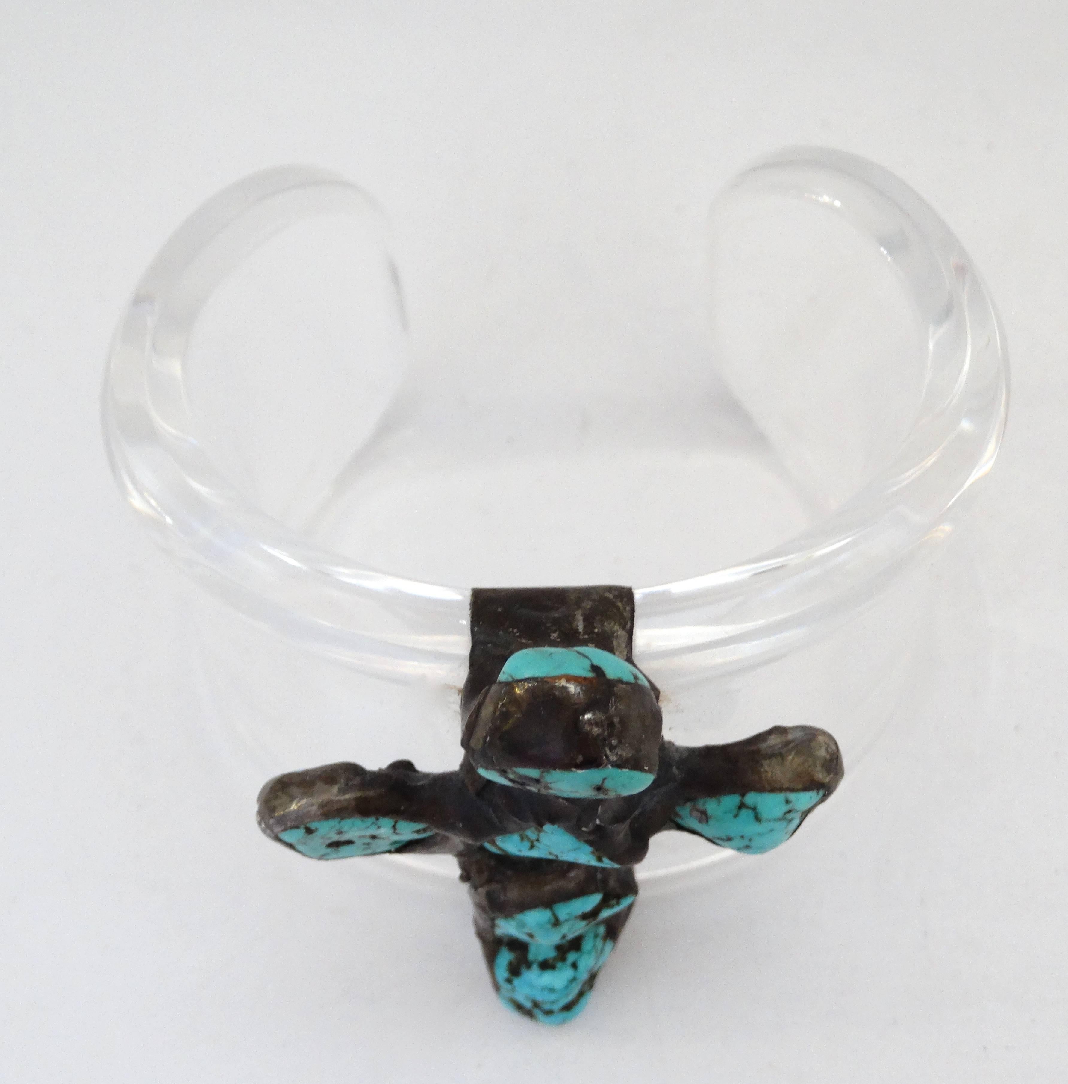 A unique take on the Navajo jewelry trend: translucent turquoise cross cuff! Clear lucite cuff with silver cross moulded around it. Chunks of turquoise embedded in the silver in a cross formation. Unsigned but of amazing quality. 


Height: 2.5 in 