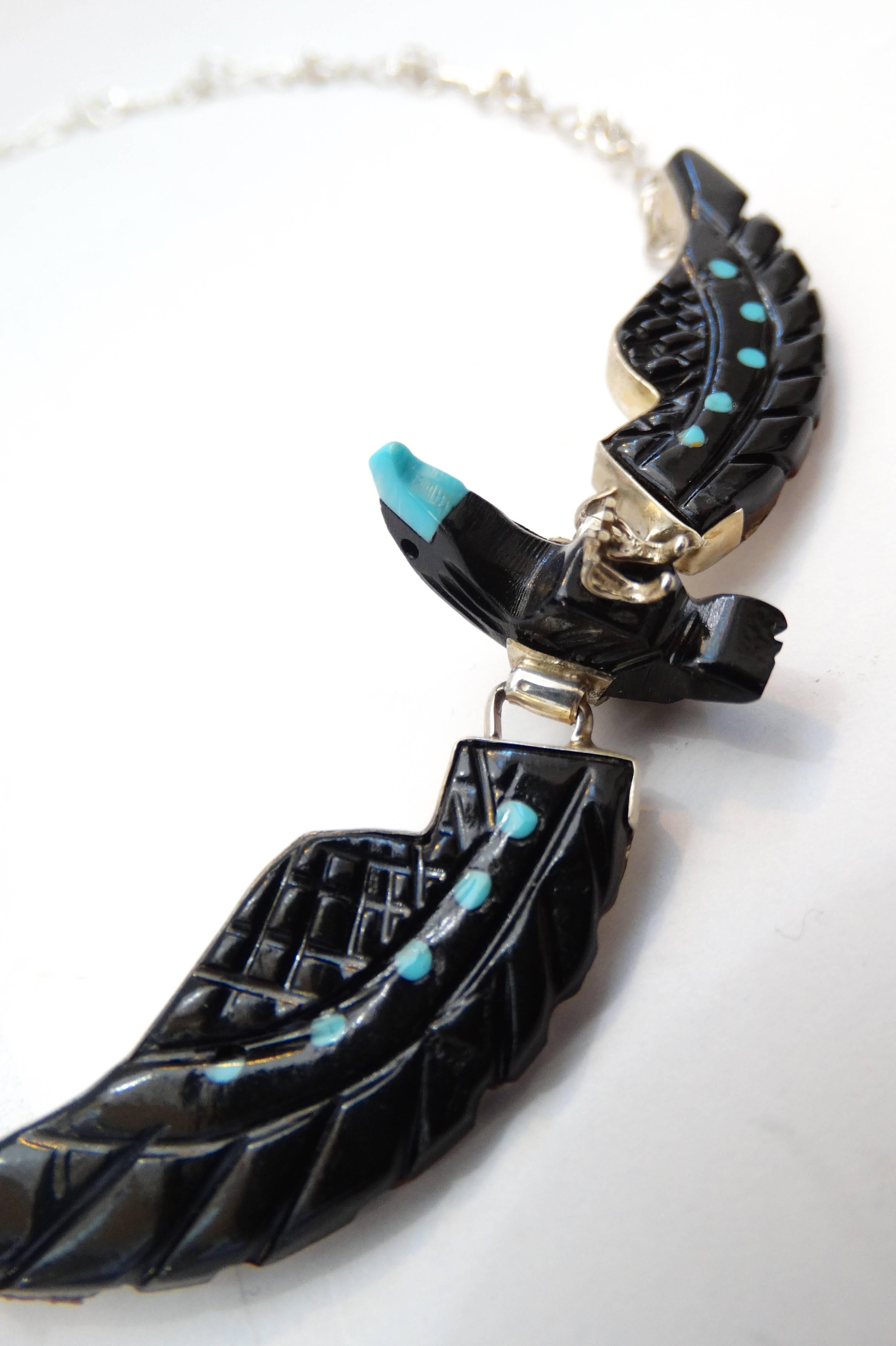 Amazing 1980s Navajo hawk necklace! Hawk charm made out of black onyx accented with bright blue toned turquoise on the wings and beak. Silver woven chain, sits higher up on the neck. Charm is backed with silver, signed Sterling on the middle of the