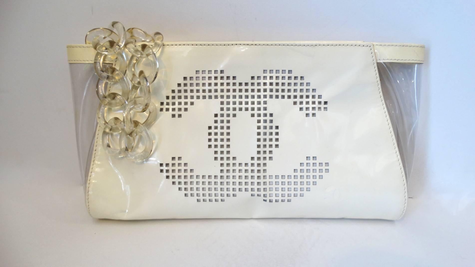 The see-thru bag craze is back in full swing- rock a piece that nobody else has with our 2003 patent clutch from Chanel! Made of a creamy white patent leather with clear peekaboo panels at either end of the bag. Large pixelated CC on one side,