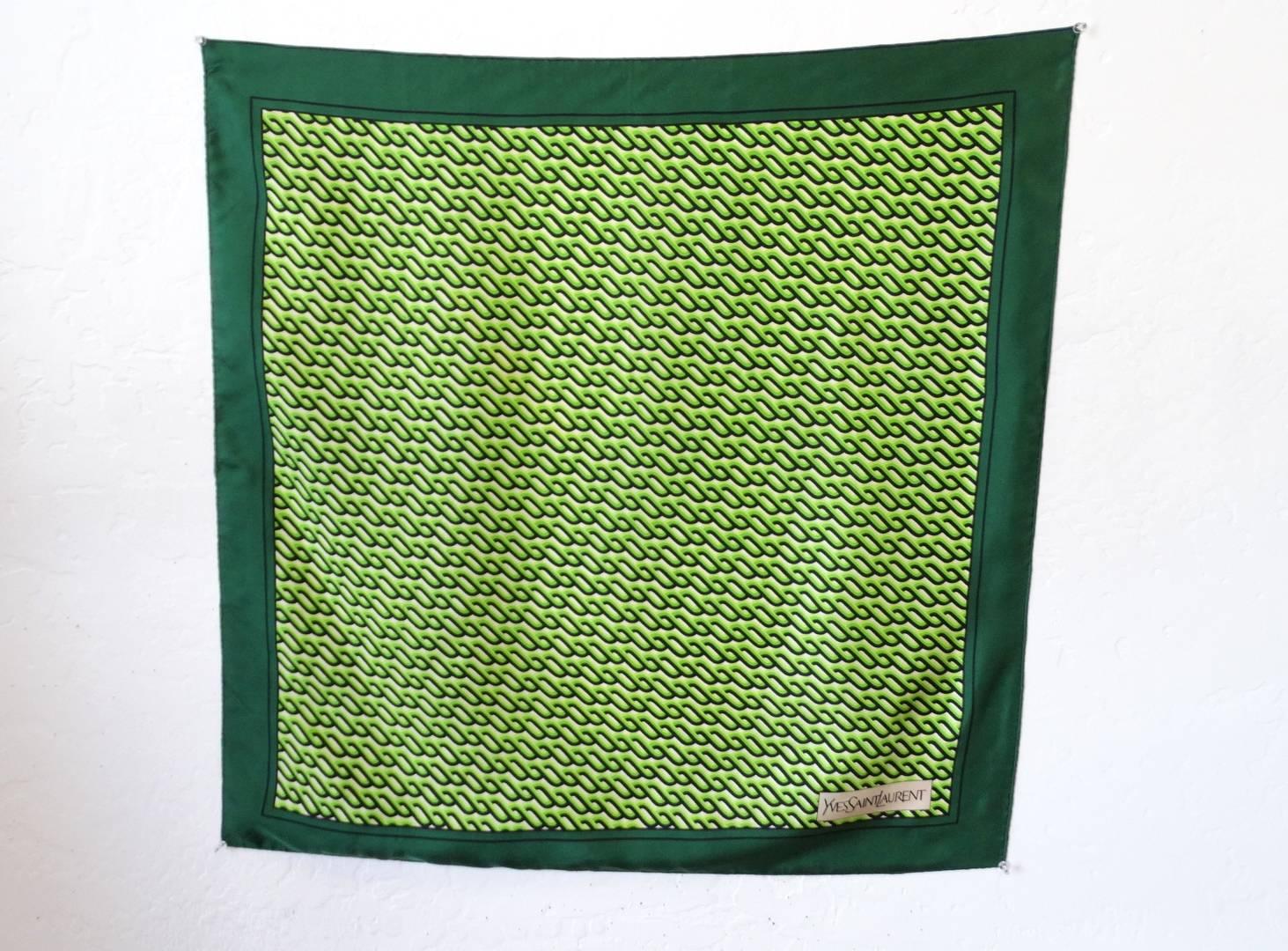 Rock the spirit of the 1970s with our amazing green patterned scarf from the iconic Yves Saint Laurent. Silk square scarf printed with a beautiful contrasting green braid inspired pattern, solid green border all around the edges. Yves Saint Laurent