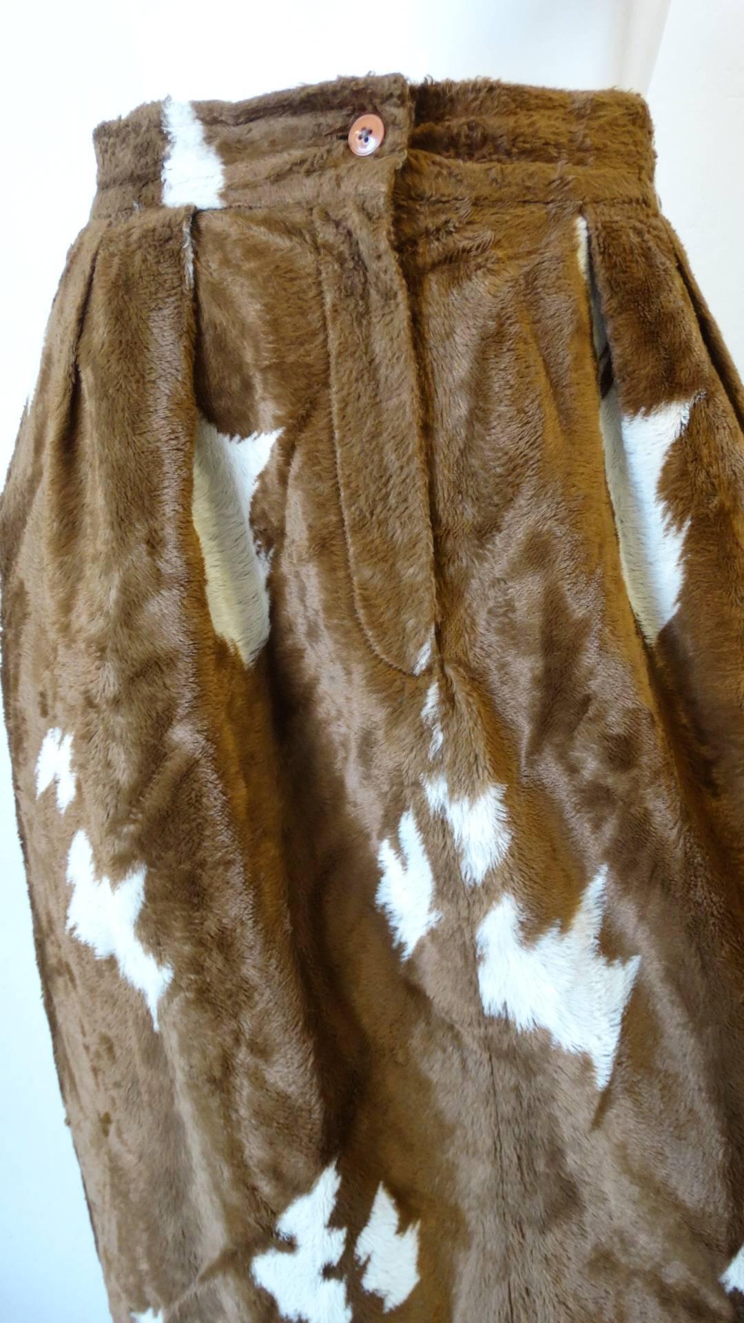 Cowgirl up with our amazing 1990s faux cowhide fuzzy pencil skirt! Made of a soft fuzzy faux fur fabric, printed with brown and white cow spots. Pencil skirt silhouette with high waisted fit and puckered waistline. Zips and buttons up the front.