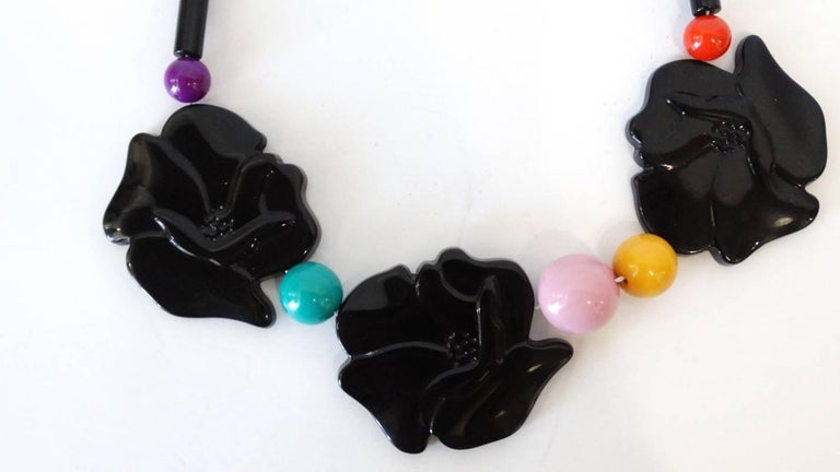 Channel your flare for the avant garde with this amazing Isadora Paris necklace from 1979! Three black bakelite oversized rose charms with multicolored beads in between each. Black beads all along the back of the neck. Screw in closure at the back.