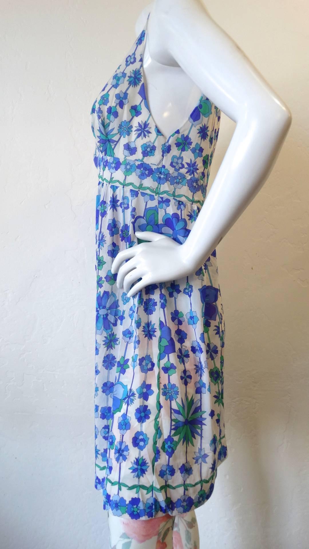 The most adorable little dress from 1960s Emilio Pucci for Formfit Rodgets! Made out of a semi sheer floral fabric in shades of blue, violet and green. Flattering v-neckline and empire waist. The perfect piece to throw over your bathing suits all