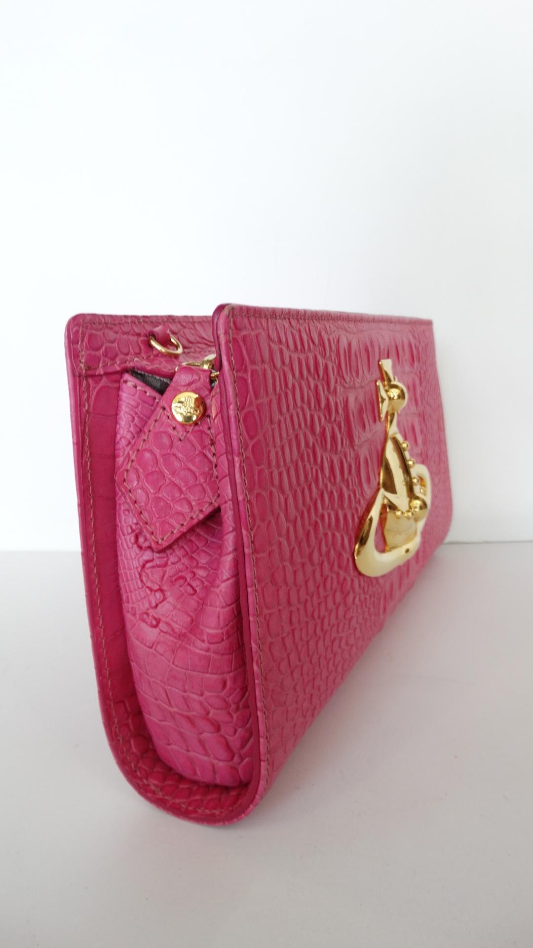 Make a  statement with our Vivienne Westwood - Classic Orb, pink moc croc embossed leather clutch bag with an oversize golden Vivienne Westwood orb, detachable strap and top zip fastening. The bag is lined in grey orb scribble print lining with a