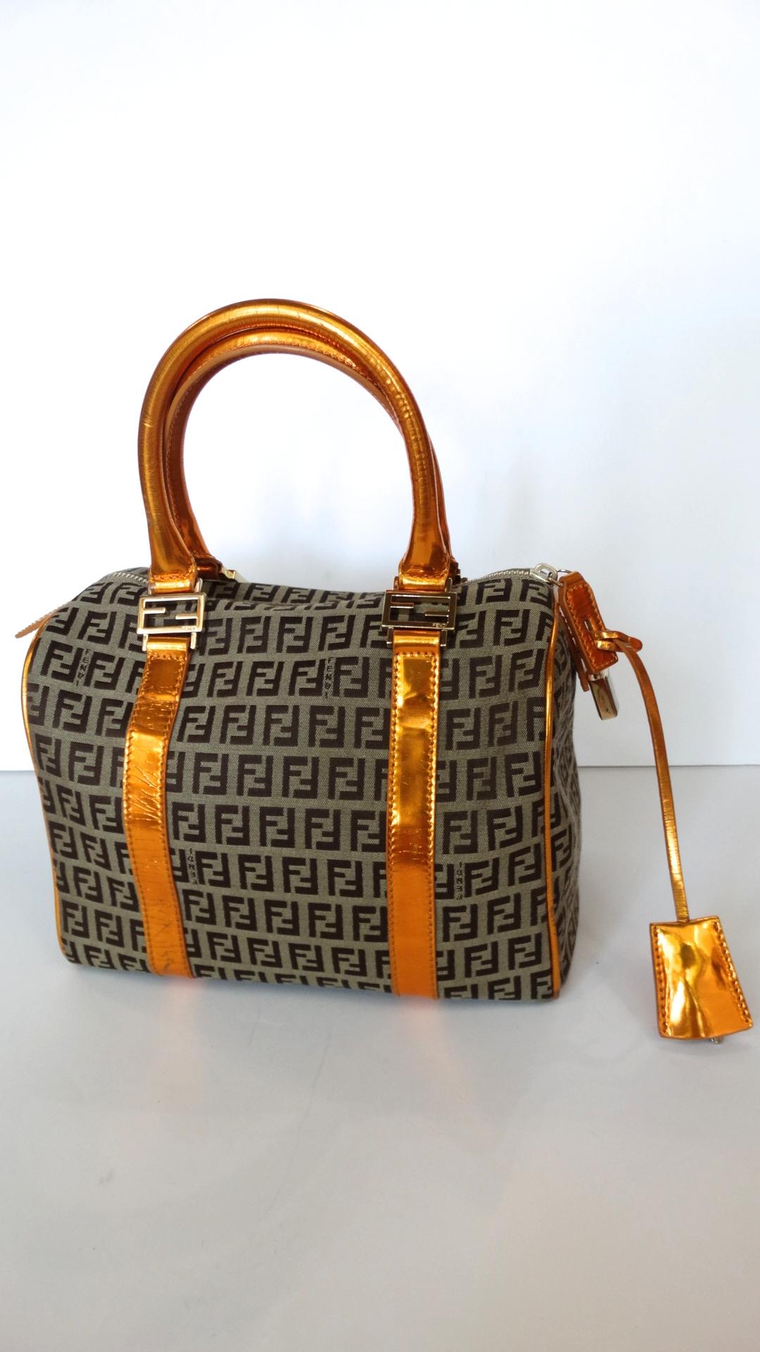 Fendi Zucca print is back! Rock the trend with our amazing Fendi Forever Zucca printed bag with orange metallic leather trim! Classic tan and brown Zucca print contrasted with glossy orange handles and matching clochette. Comes with original silver
