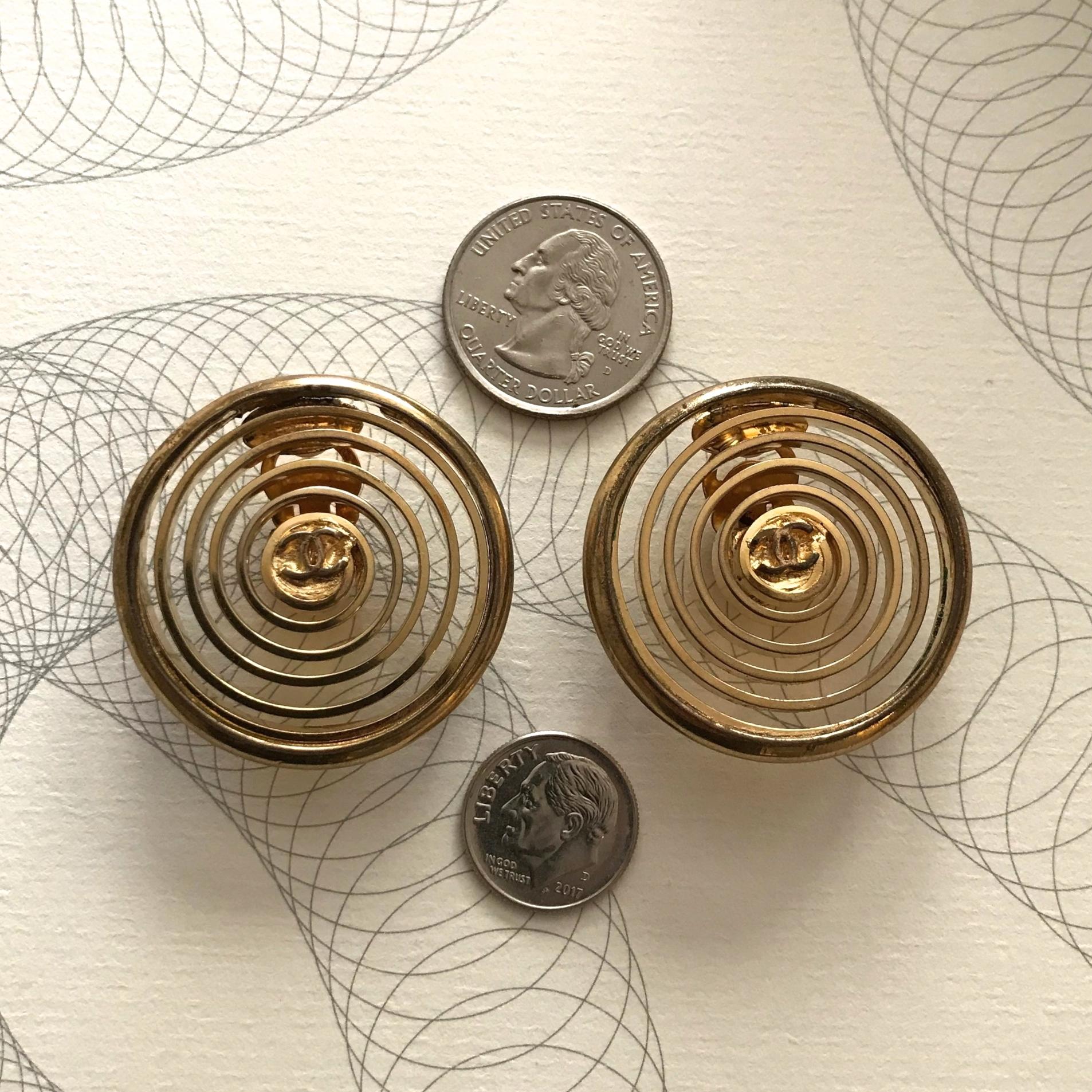 Get hypnotized by our adorable 1980s Chanel spiral earrings! Thin gold metal spirals with little CC's in the middle of each. Oversized silhouette. Clip on backs. Marked 