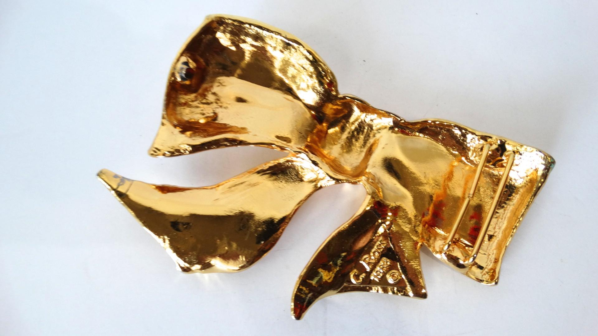 Make a statement in this Christopher Ross Bow Belt Buckle from 1983! The textured plated gold metal and freely structured shape of the bow gives the illusion of fabric. Signed C. Ross 1983 on the back. 

Length: 5